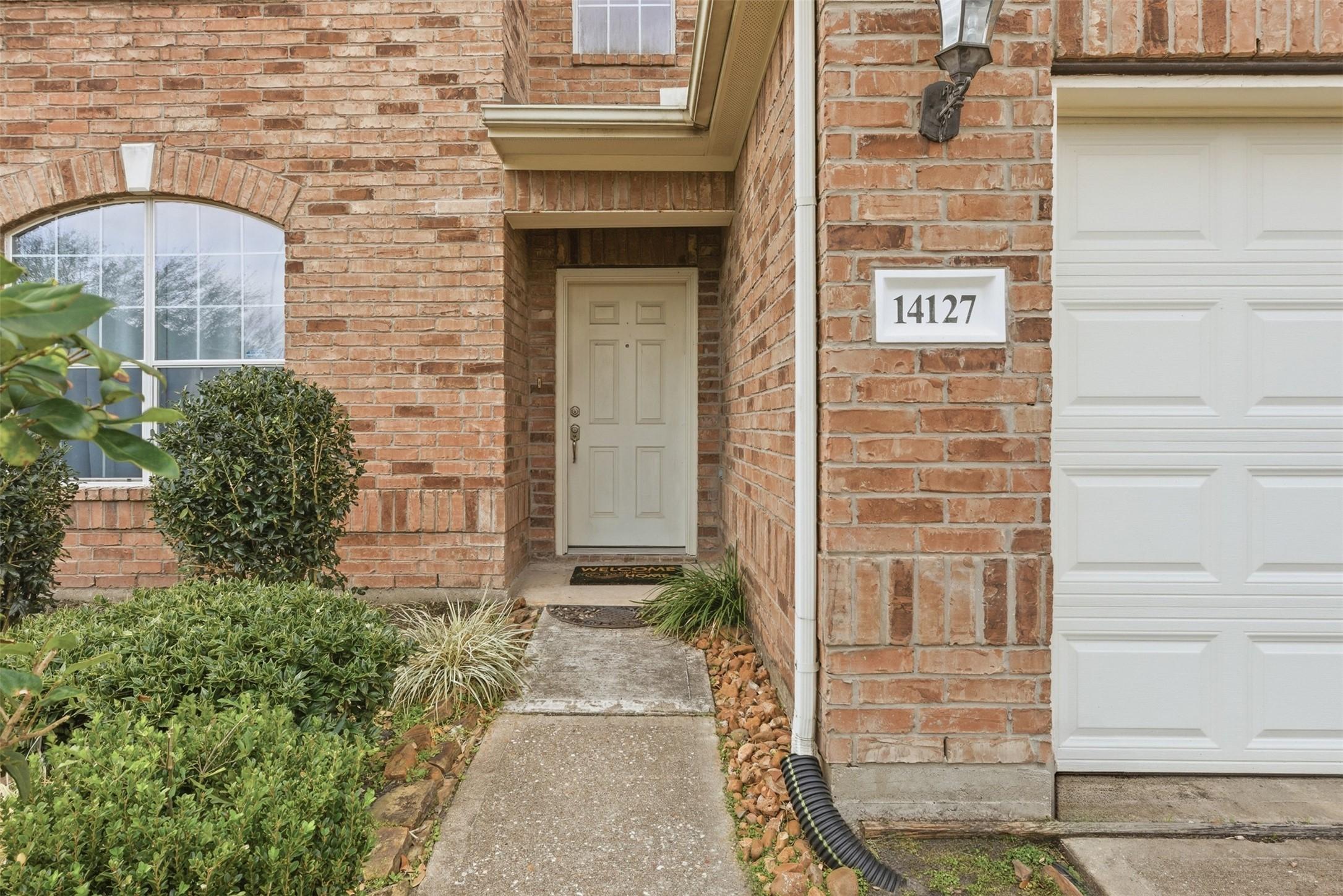 Image 3: Covered front entry with a private walkway and cha