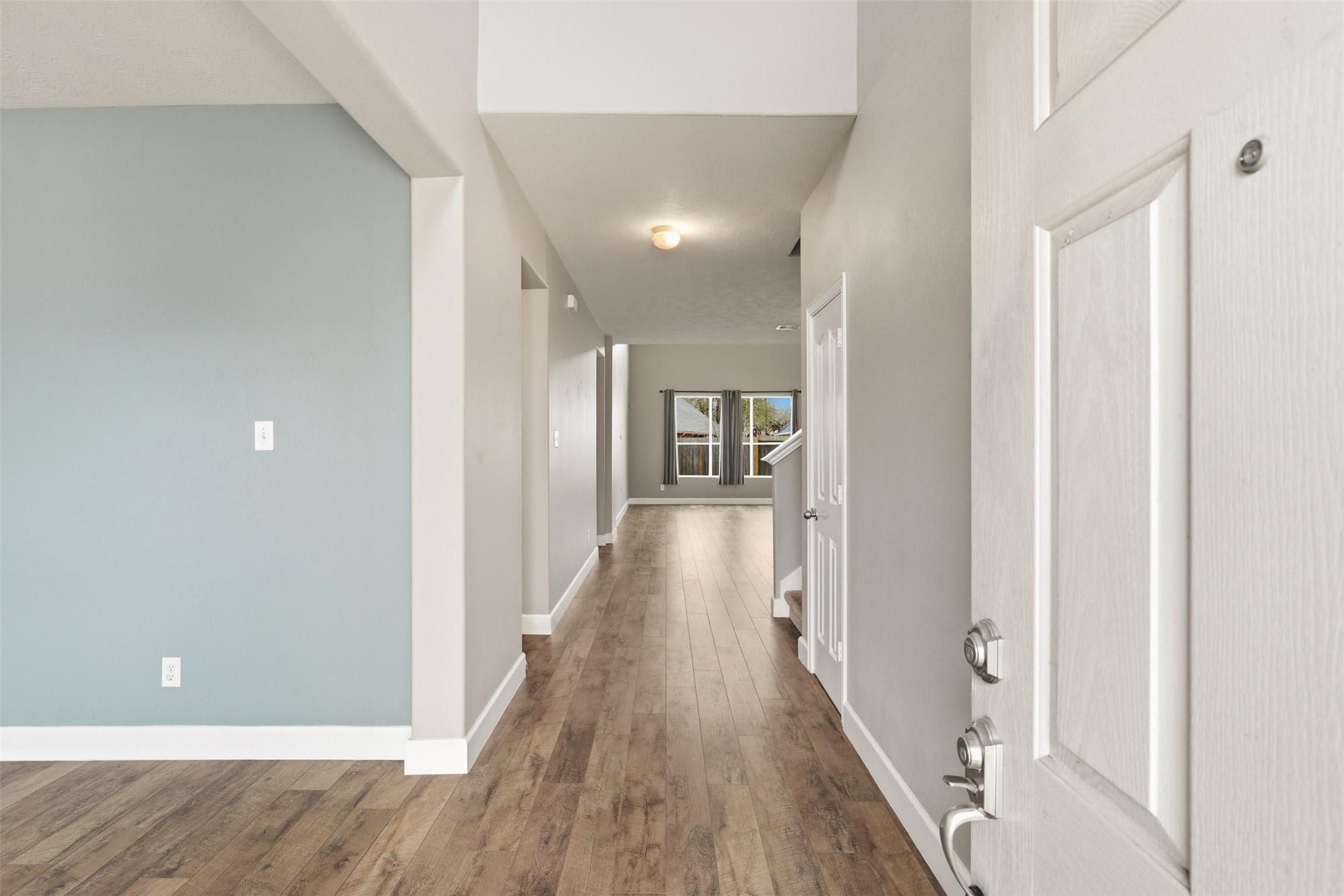 Image 4: Grand entry hallway with high ceilings and wood-st