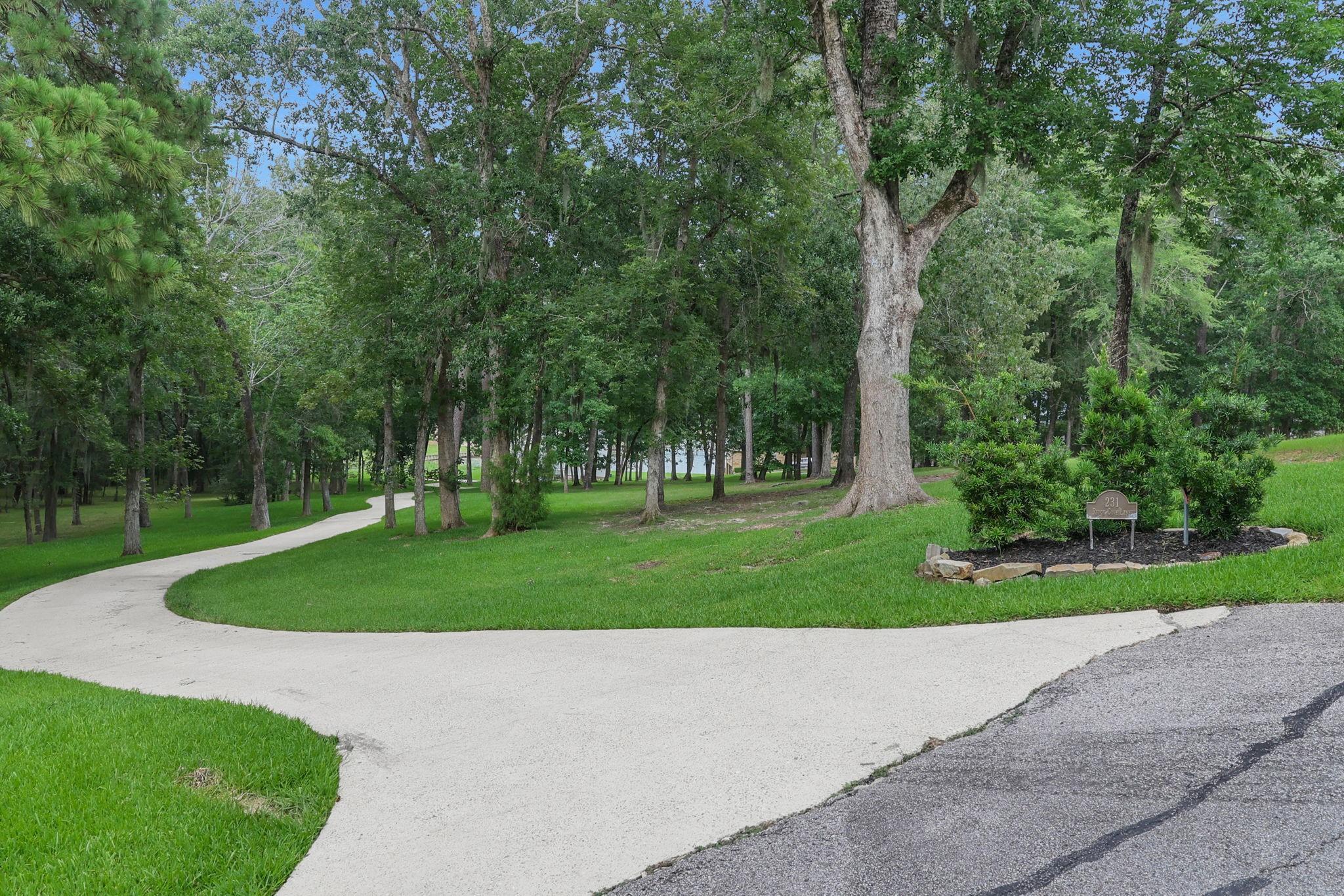 Image 2: A long, winding driveway creates a welcoming appro