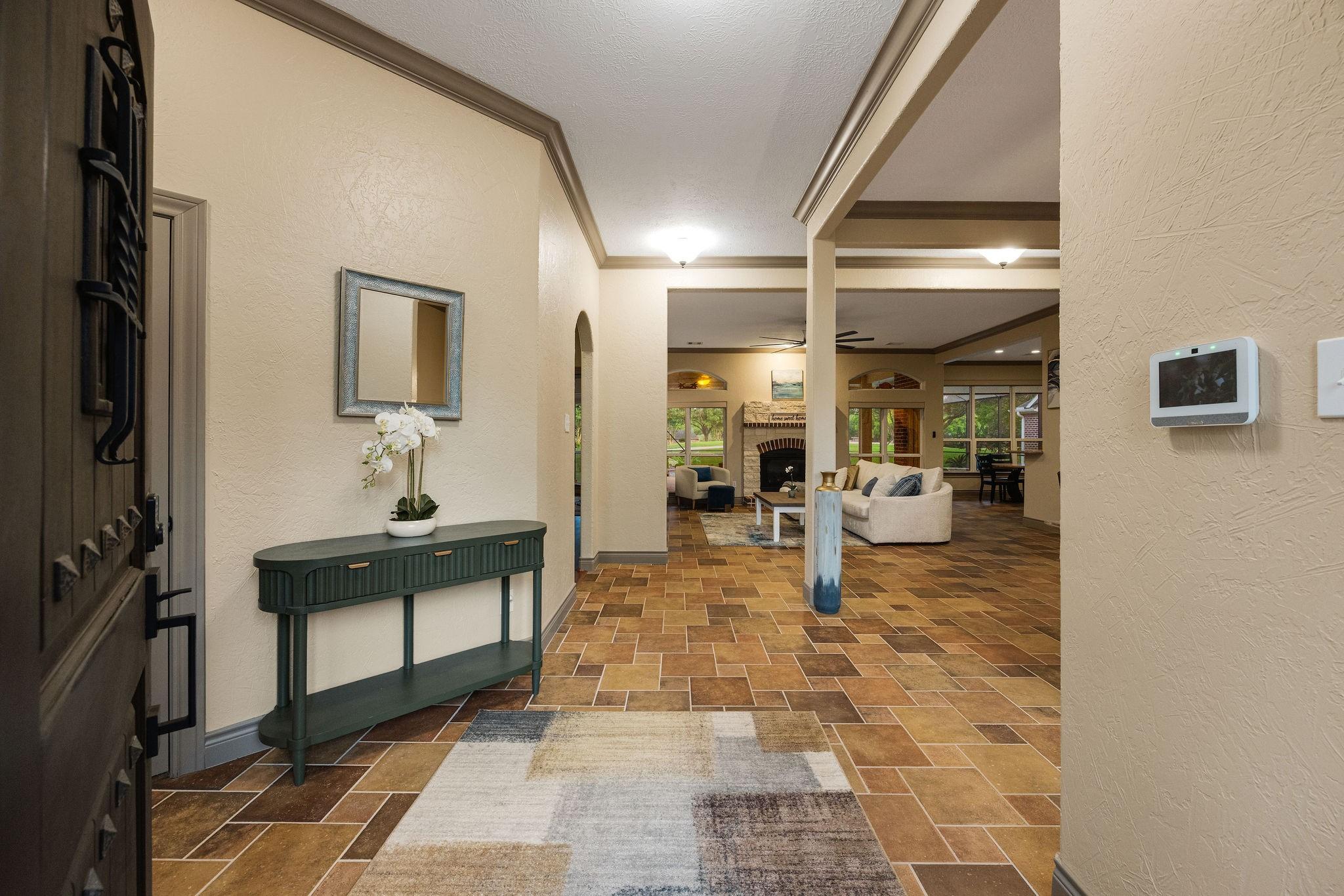 Image 4: A welcoming entryway with neutral walls and tile f