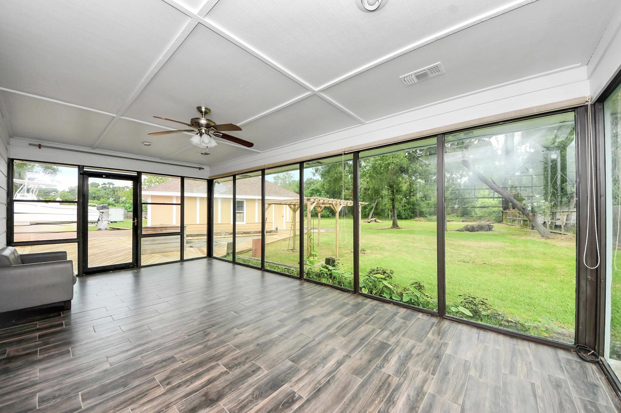 Image 4: This sunroom features expansive floor-to-ceiling w