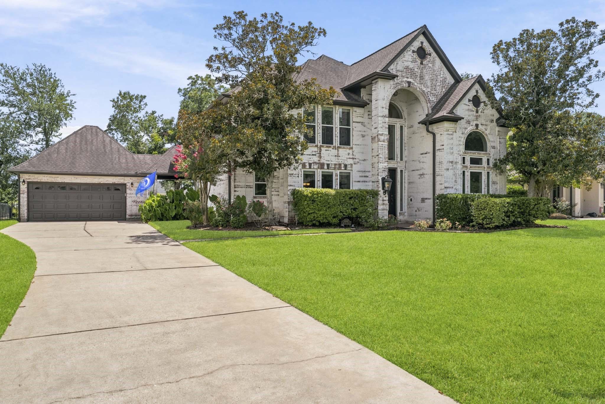 Image 4: The extra-wide driveway leads to the home&rsquo;s 2-car