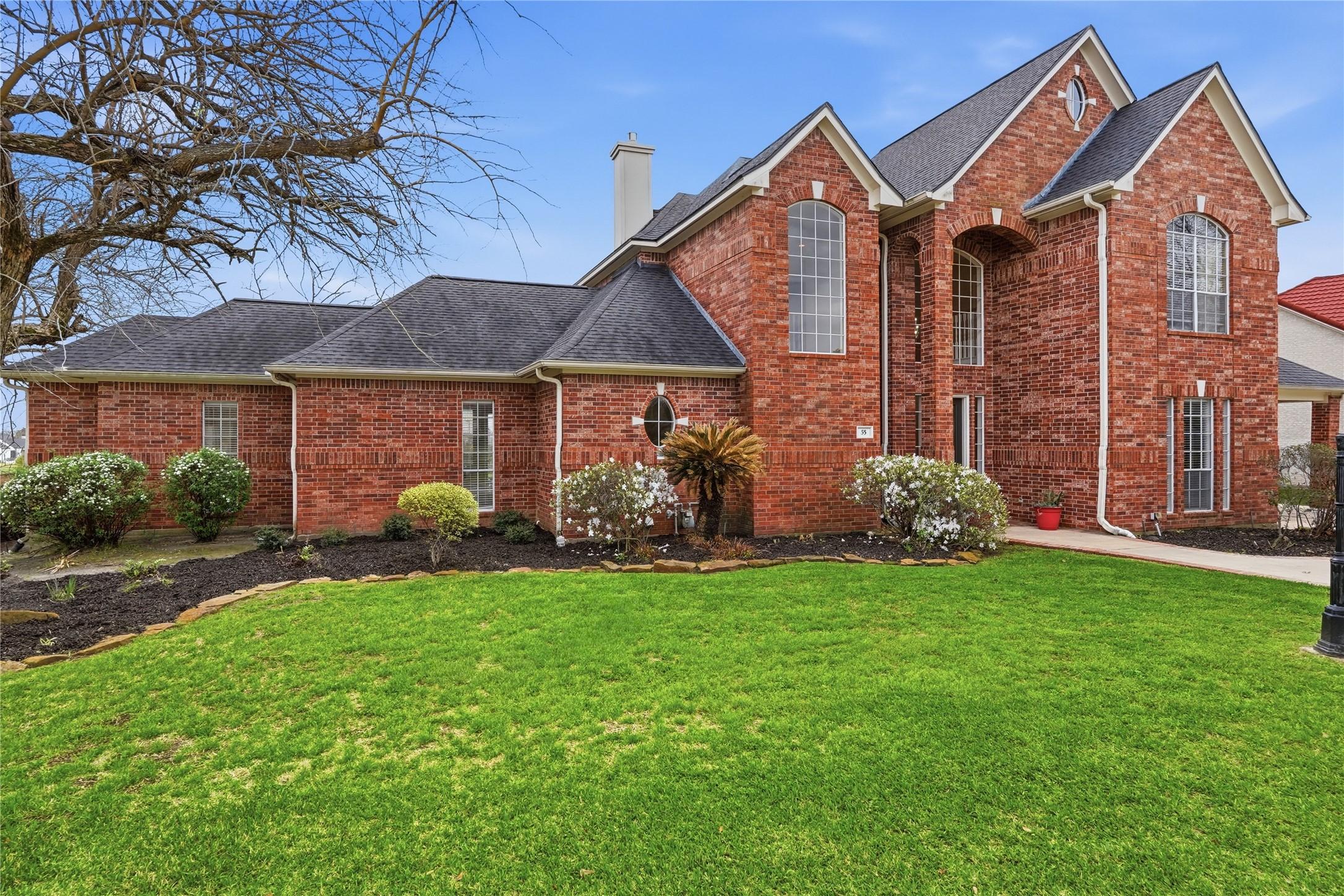 Image 2: This elegant two-story brick home features large a