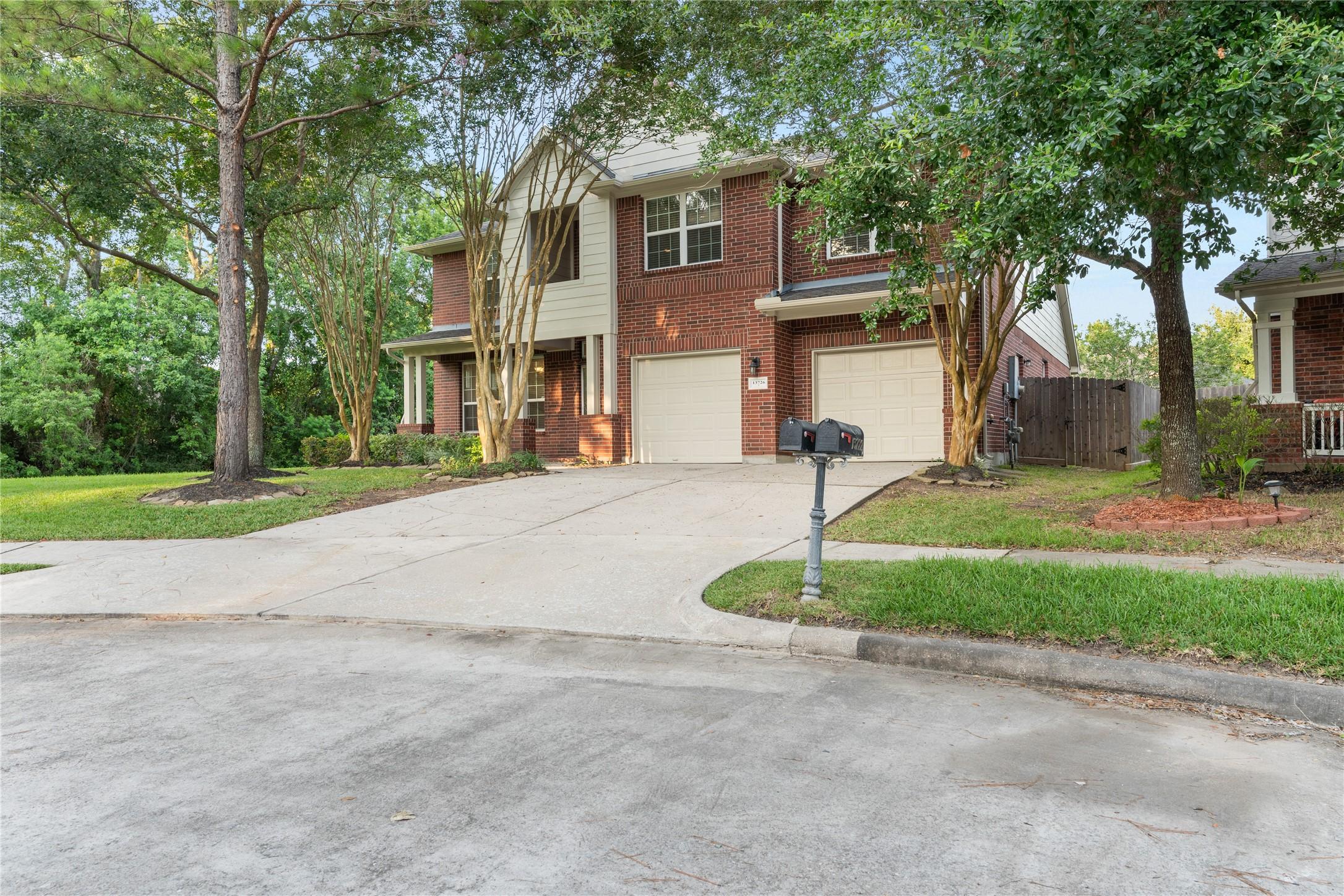 Image 3: This two-story brick home features a double garage