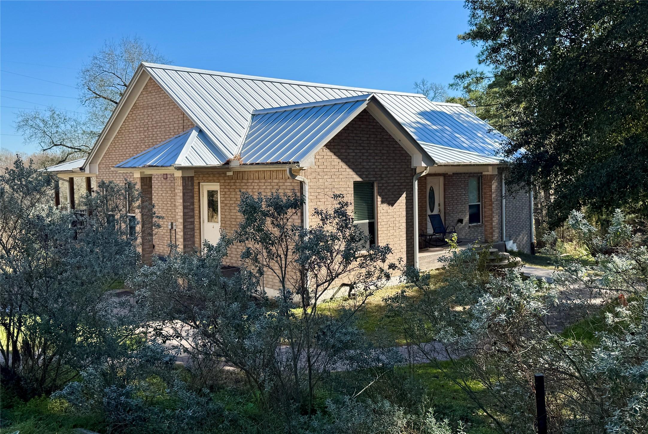 Image 3: Spacious brick home with a metal roof, nestled amo