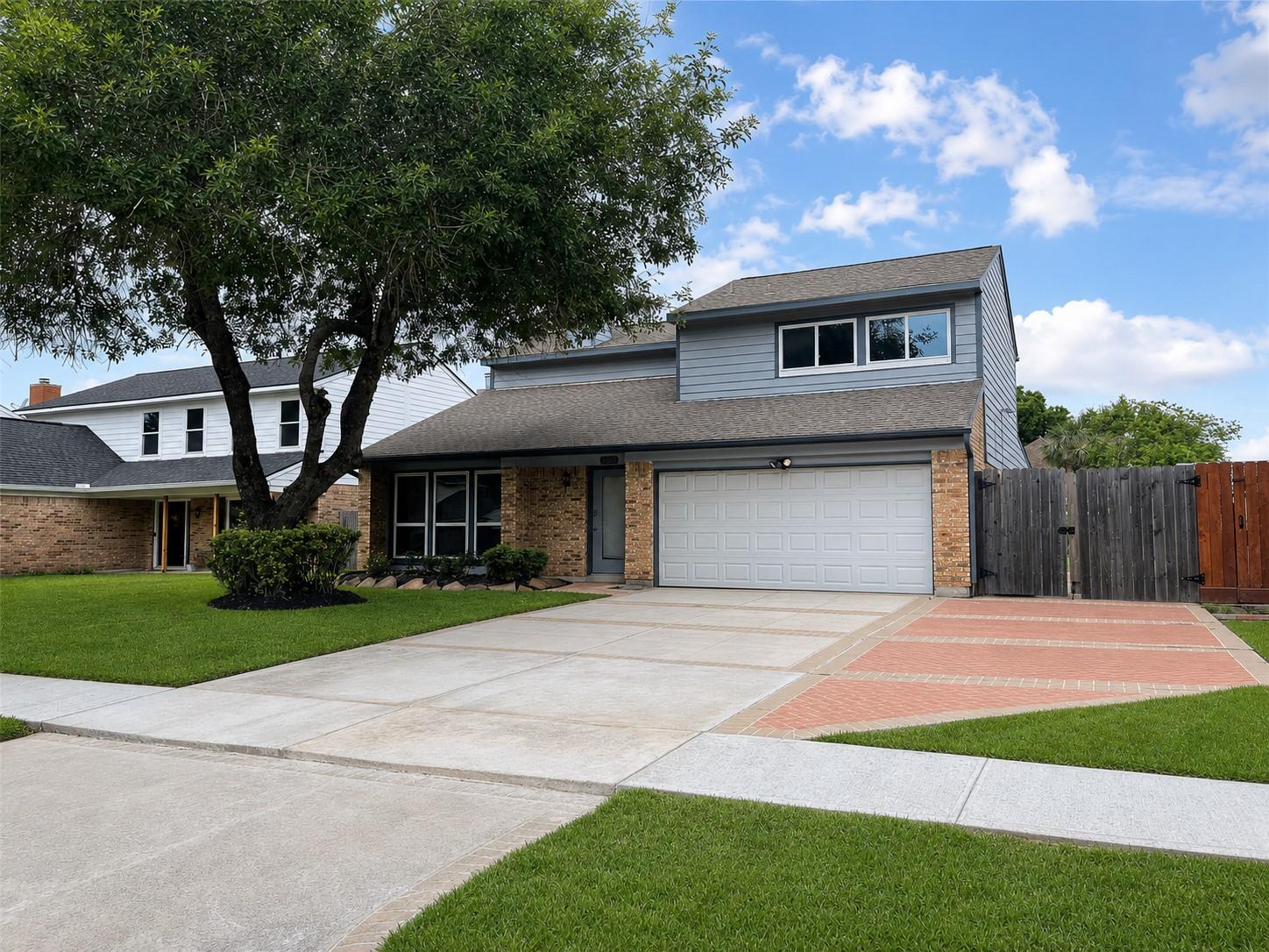 Image 2: Front exterior with two-car garage, extended drive