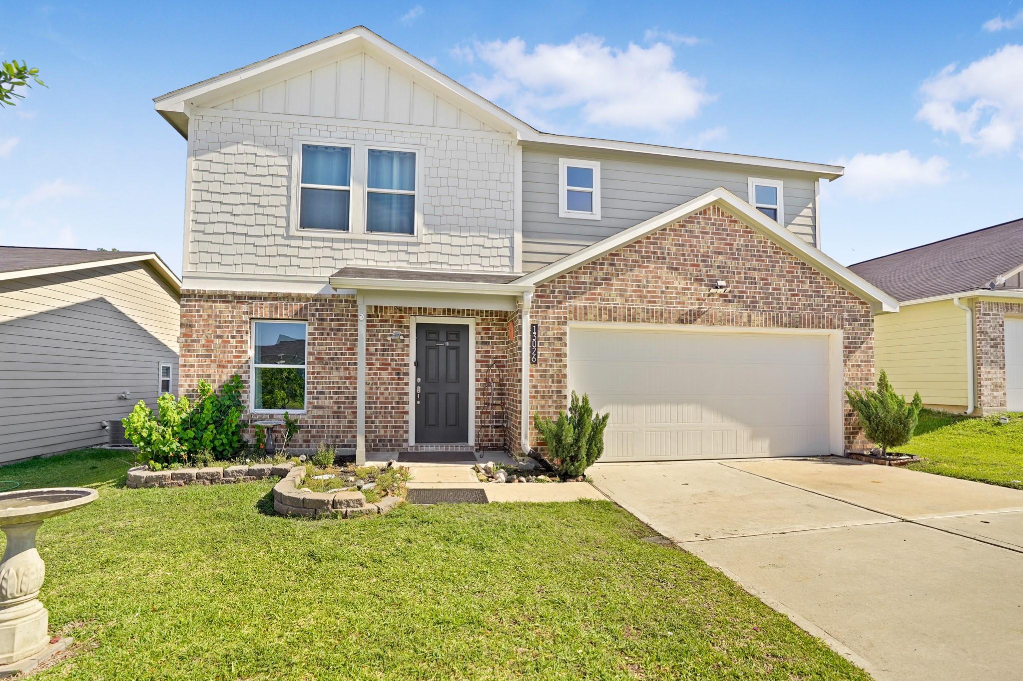 Image 2: Charming two-story home with a brick facade and a