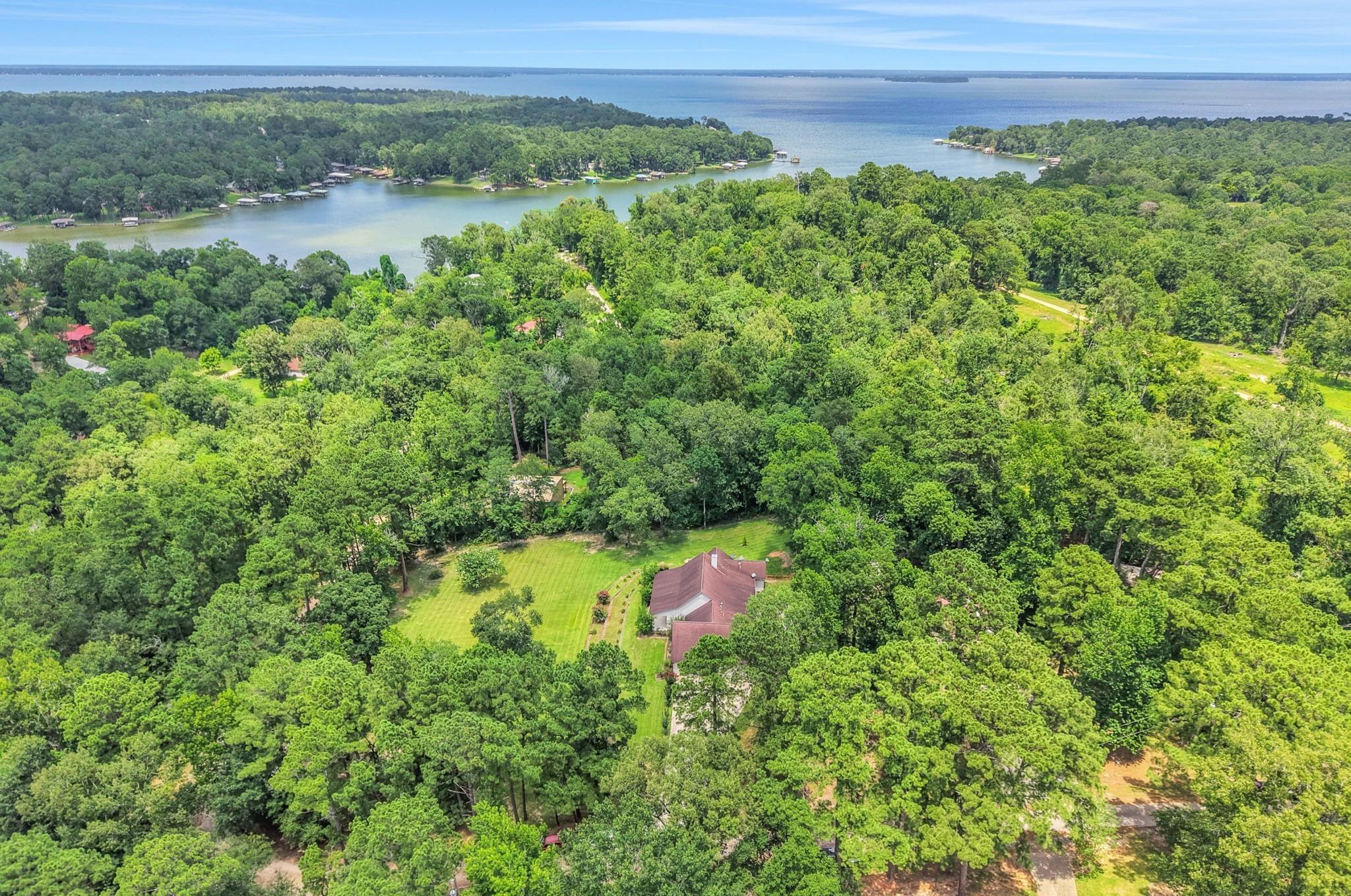 Image 2: Nestled among mature trees, this aerial view showc