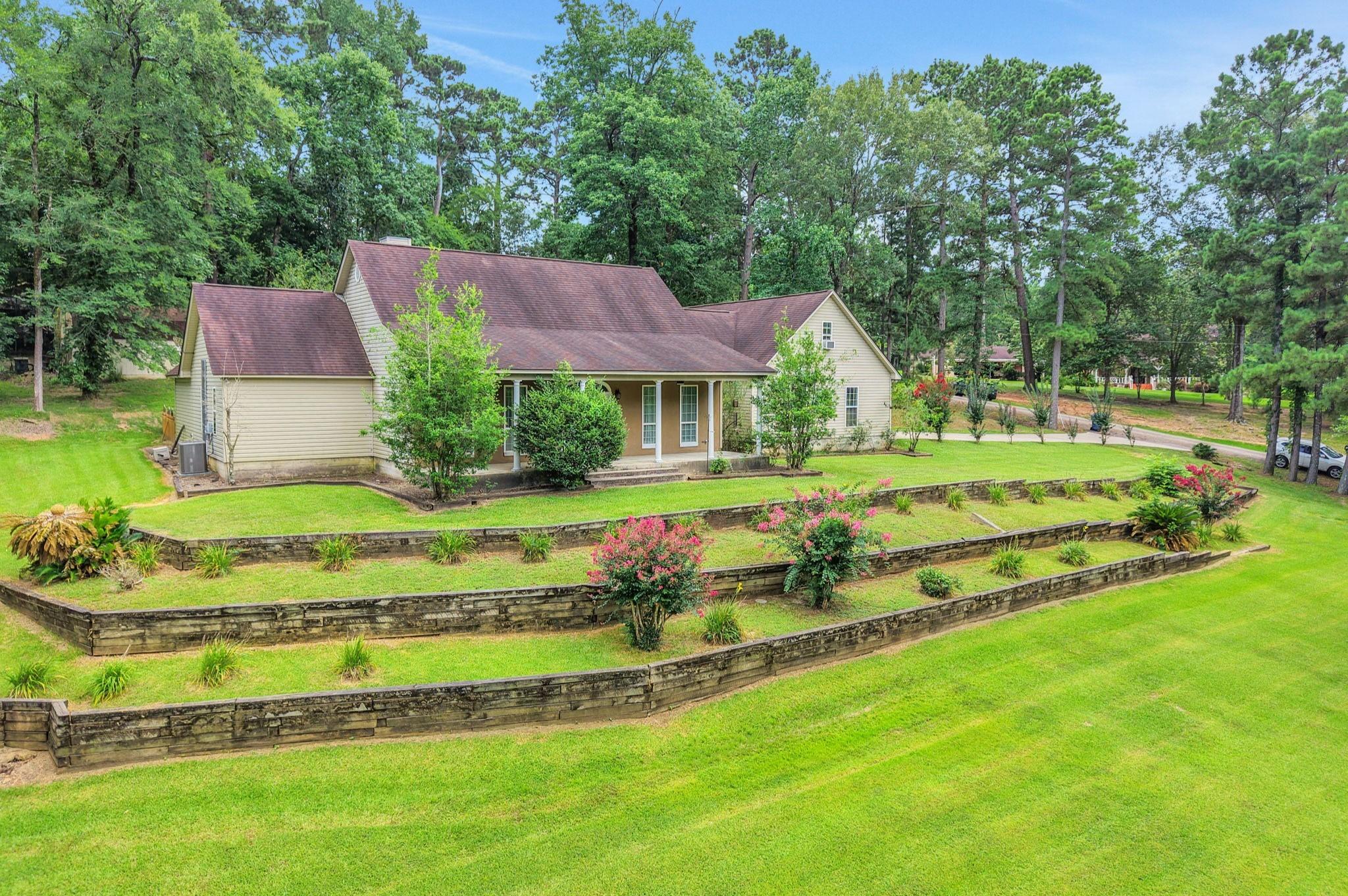 Image 3: The home's beautifully landscaped front yard makes