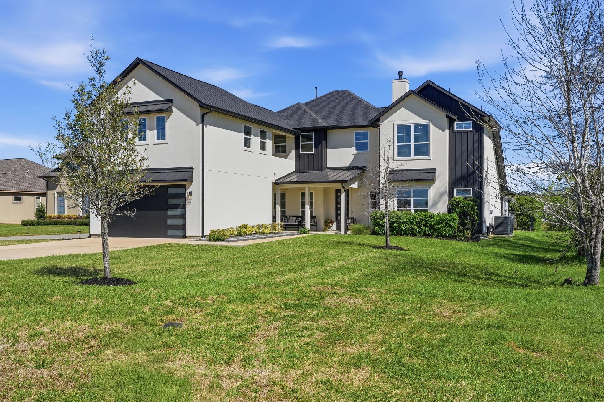 Image 3: This photo shows a modern two-story home with a mi
