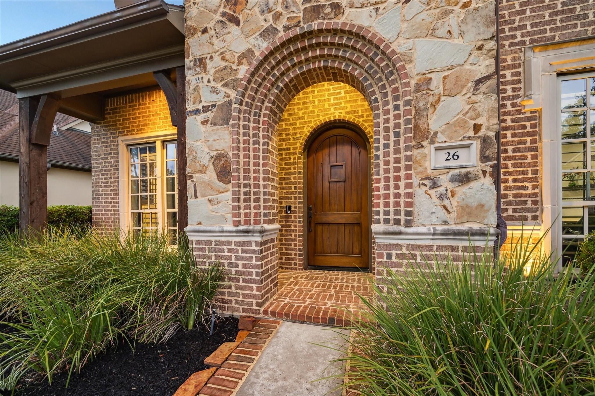 Image 3: Arched brick entryway with cast stone accents fram