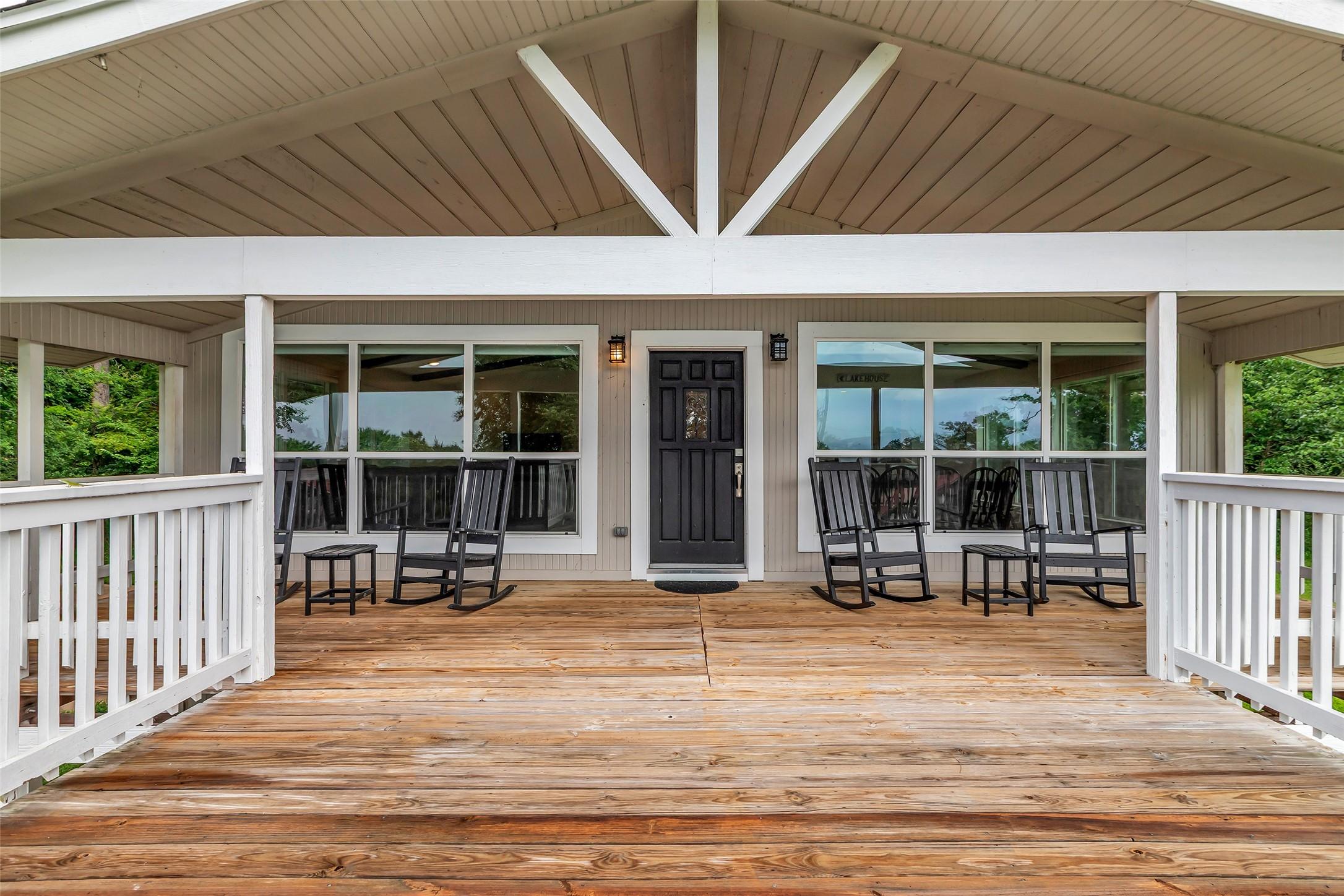 Image 1: This inviting porch features a spacious wooden dec