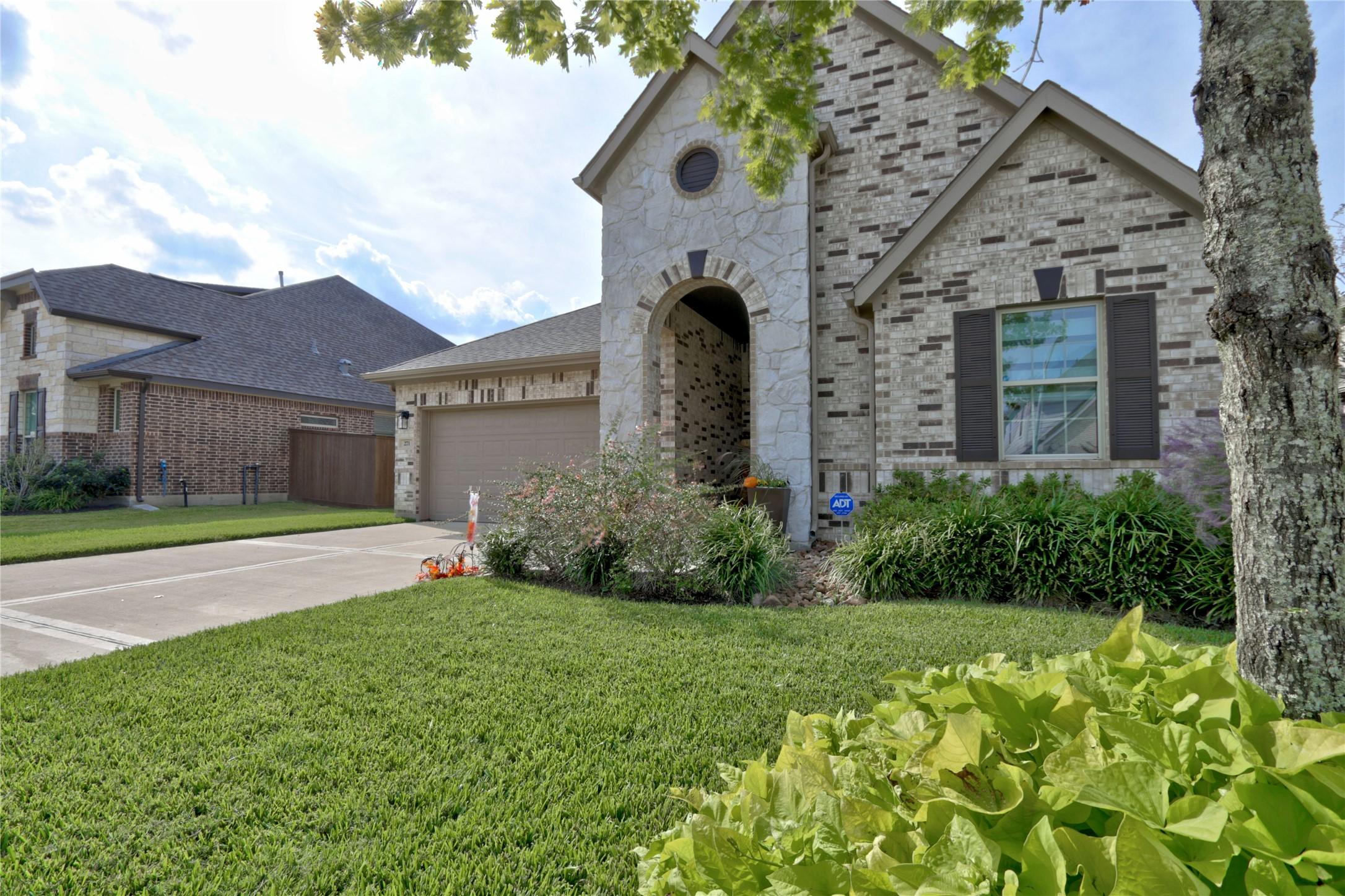 Image 3: Featuring a two-car garage and well-maintained lan