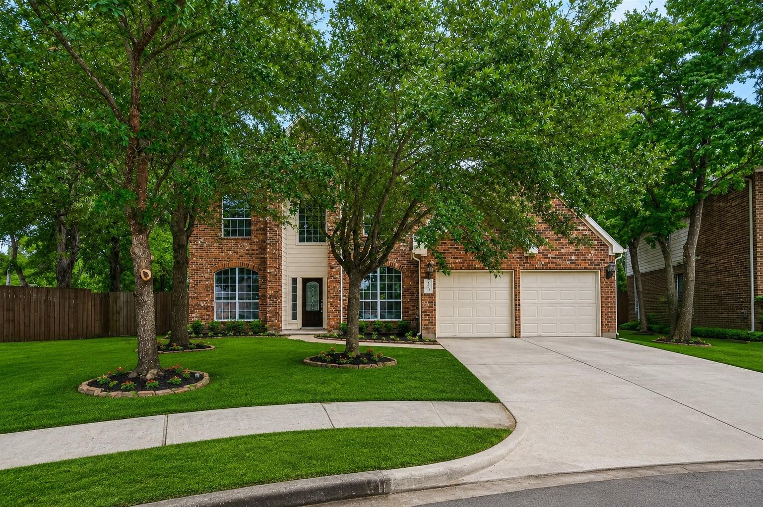 Image 3: Nestled among mature trees, this two-story brick h