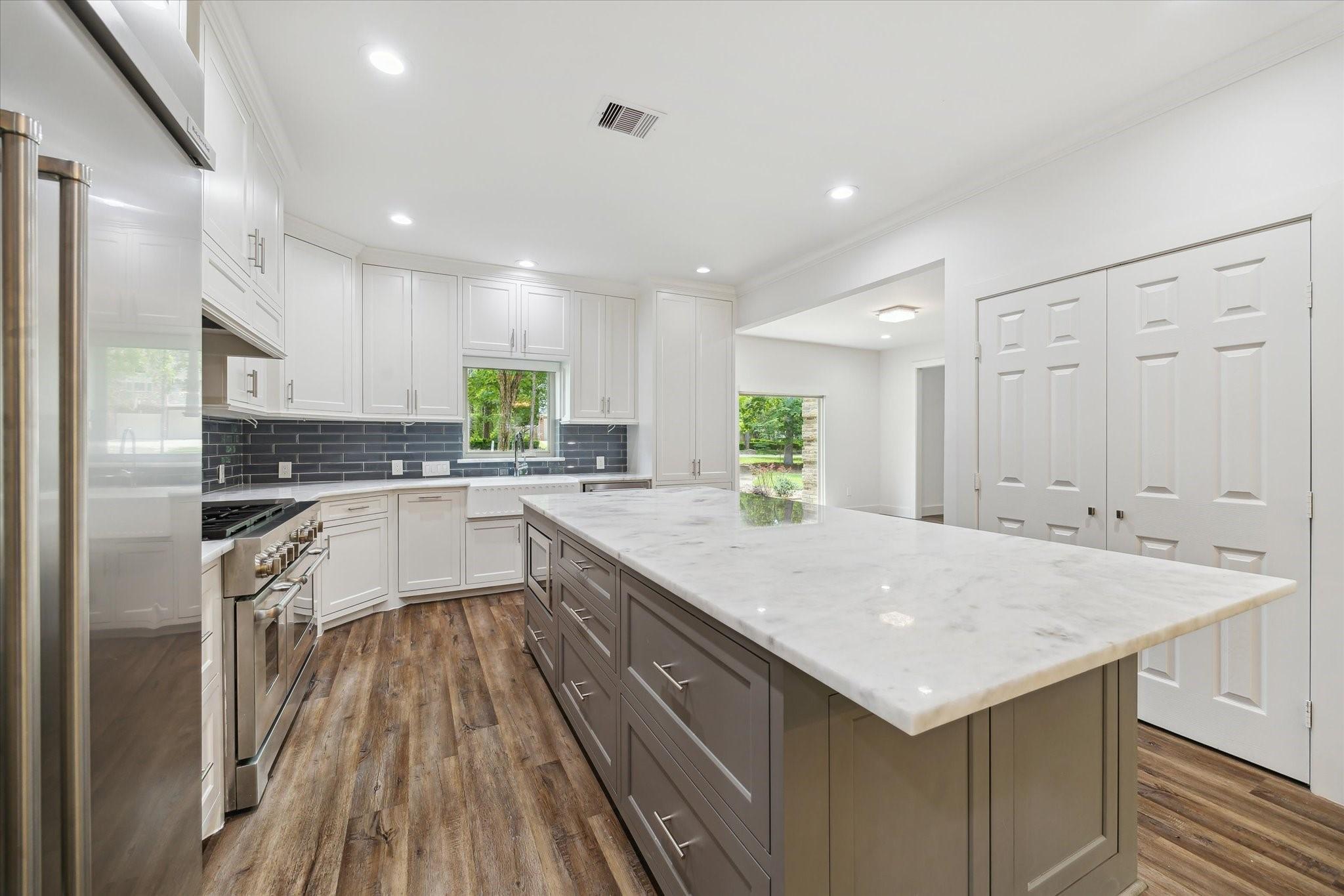 Image 1: This modern kitchen showcases a spacious island fe