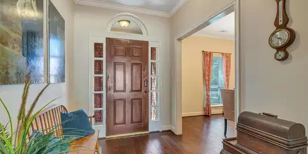 Image 4: Charming entryway with a solid wood door, leading