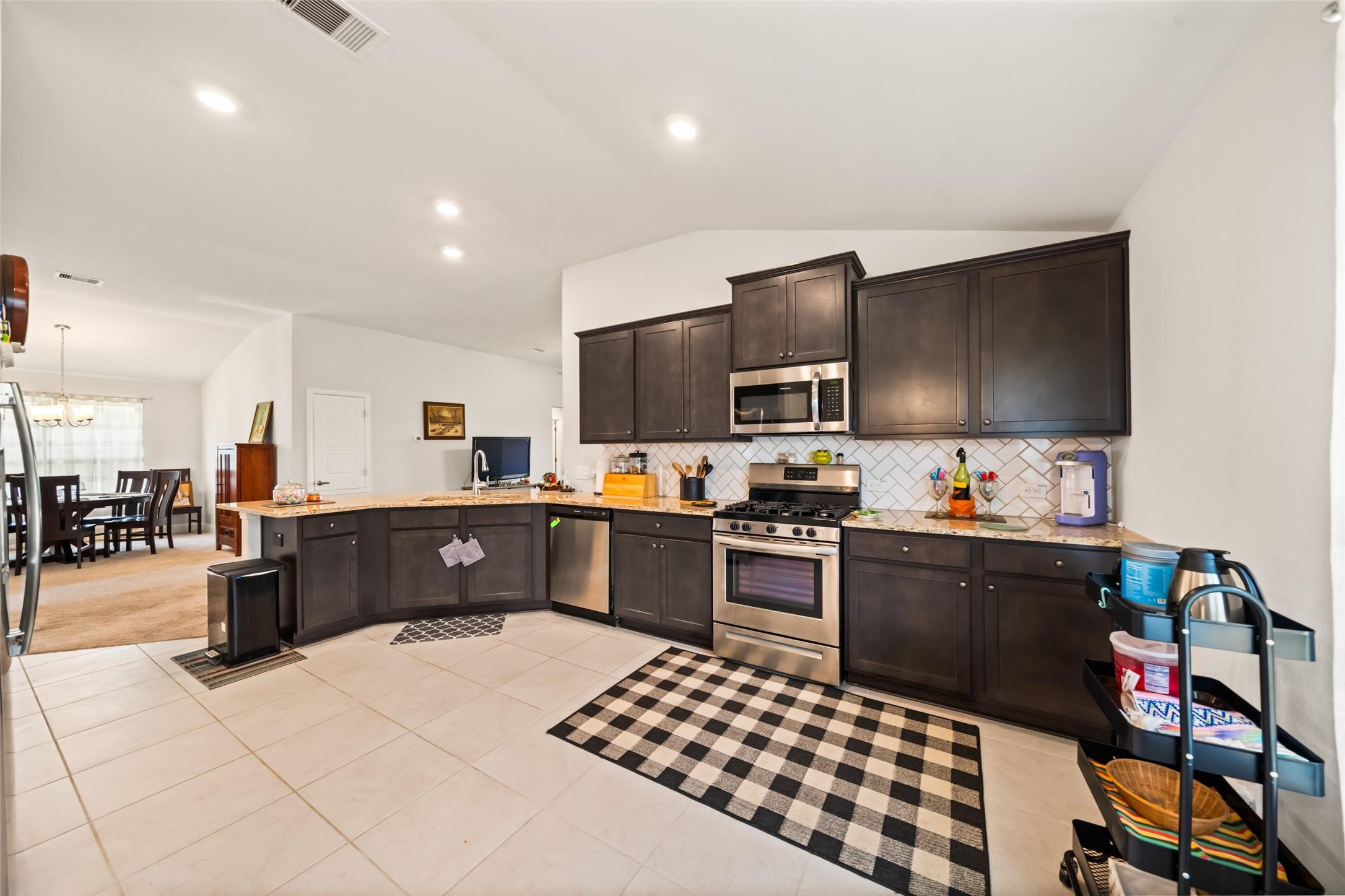 Image 4: This photo showcases a modern kitchen with granite