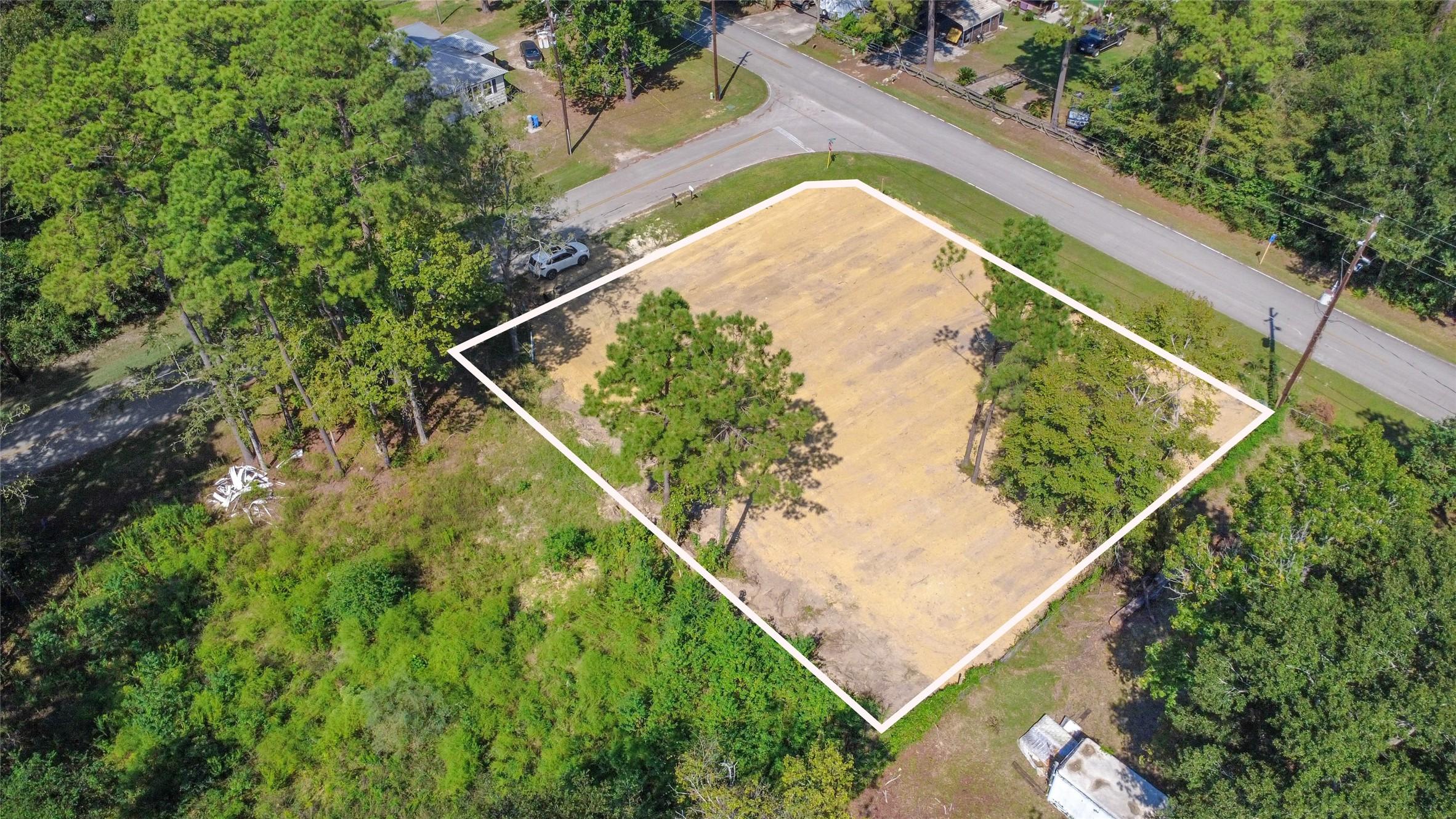 Image 3: Expansive cleared lot surrounded by lush greenery,