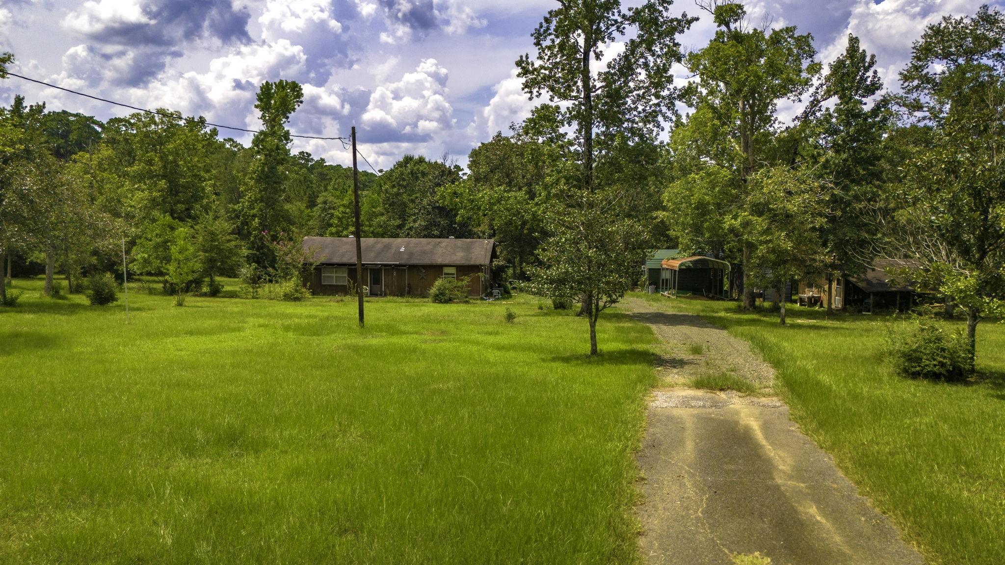 Image 1: This photo shows a rustic home set in a spacious,
