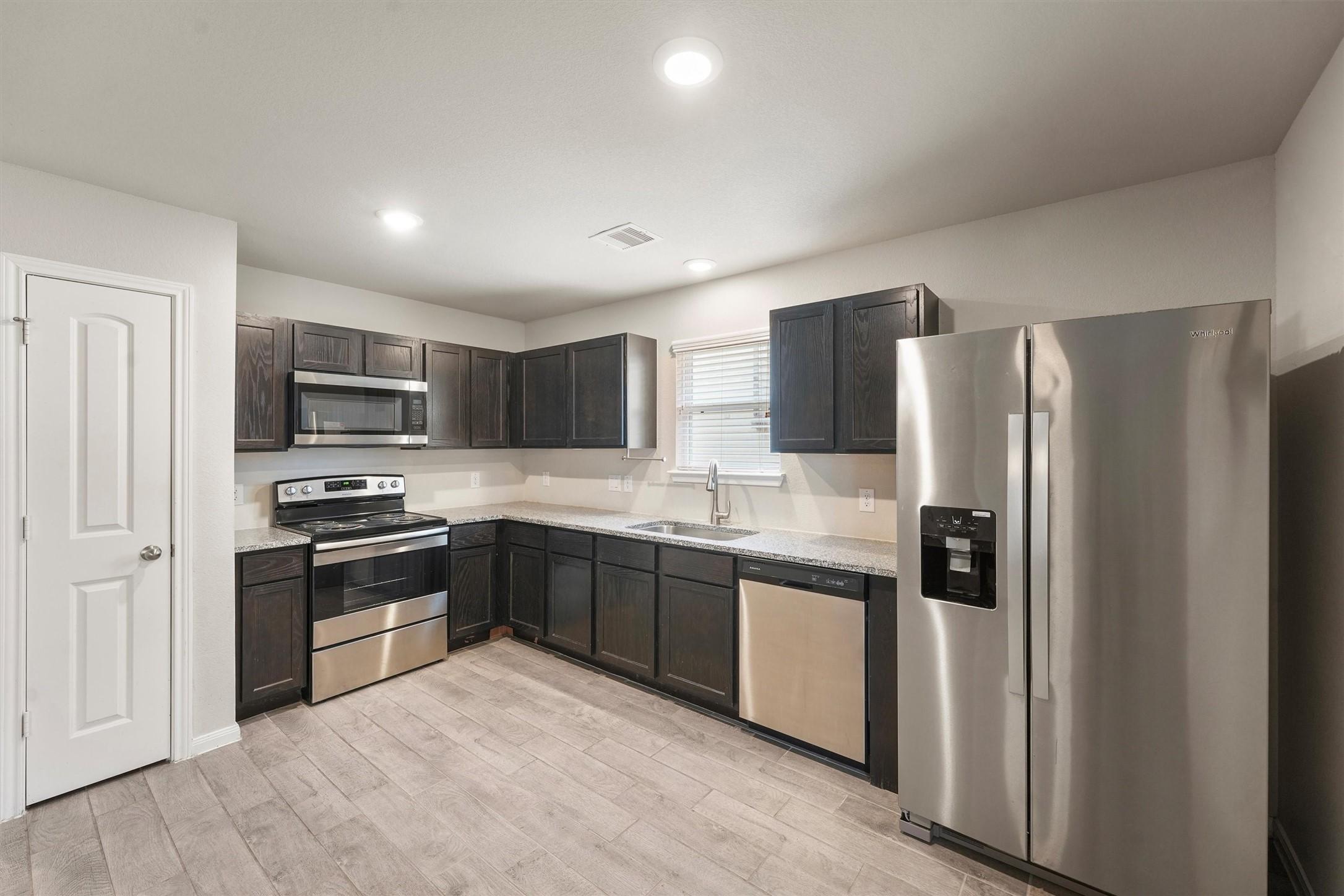 Image 4: A well-appointed kitchen features granite countert