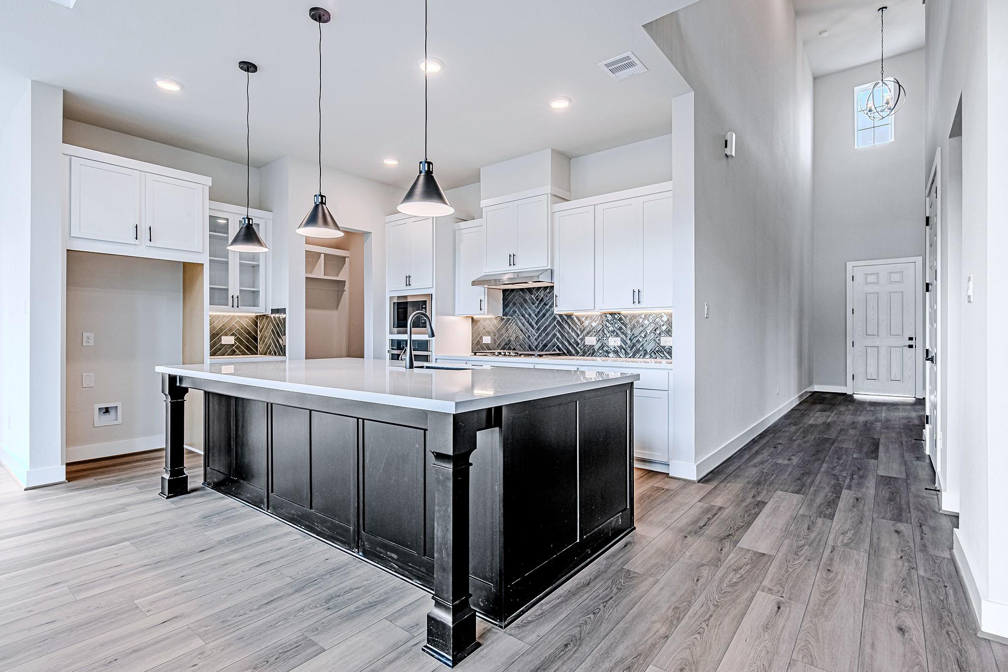 Image 4: Open-concept kitchen with a large island, pendant