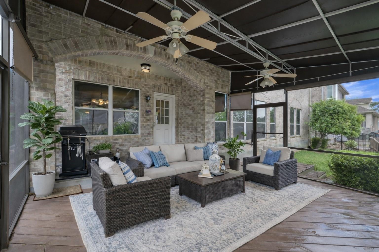 Image 3: Screened-in porch features ceiling fans, gas grill