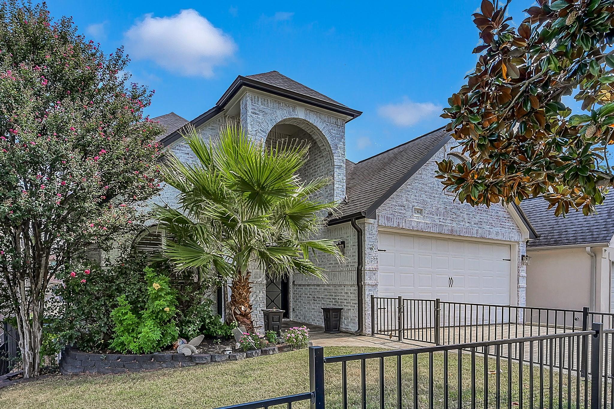 Image 3: Lush, mature landscaping creates a welcoming front