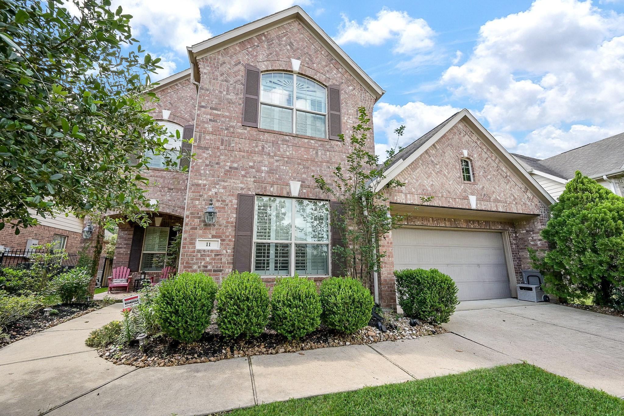 Image 3: Beautiful brick exterior with lush landscaping and