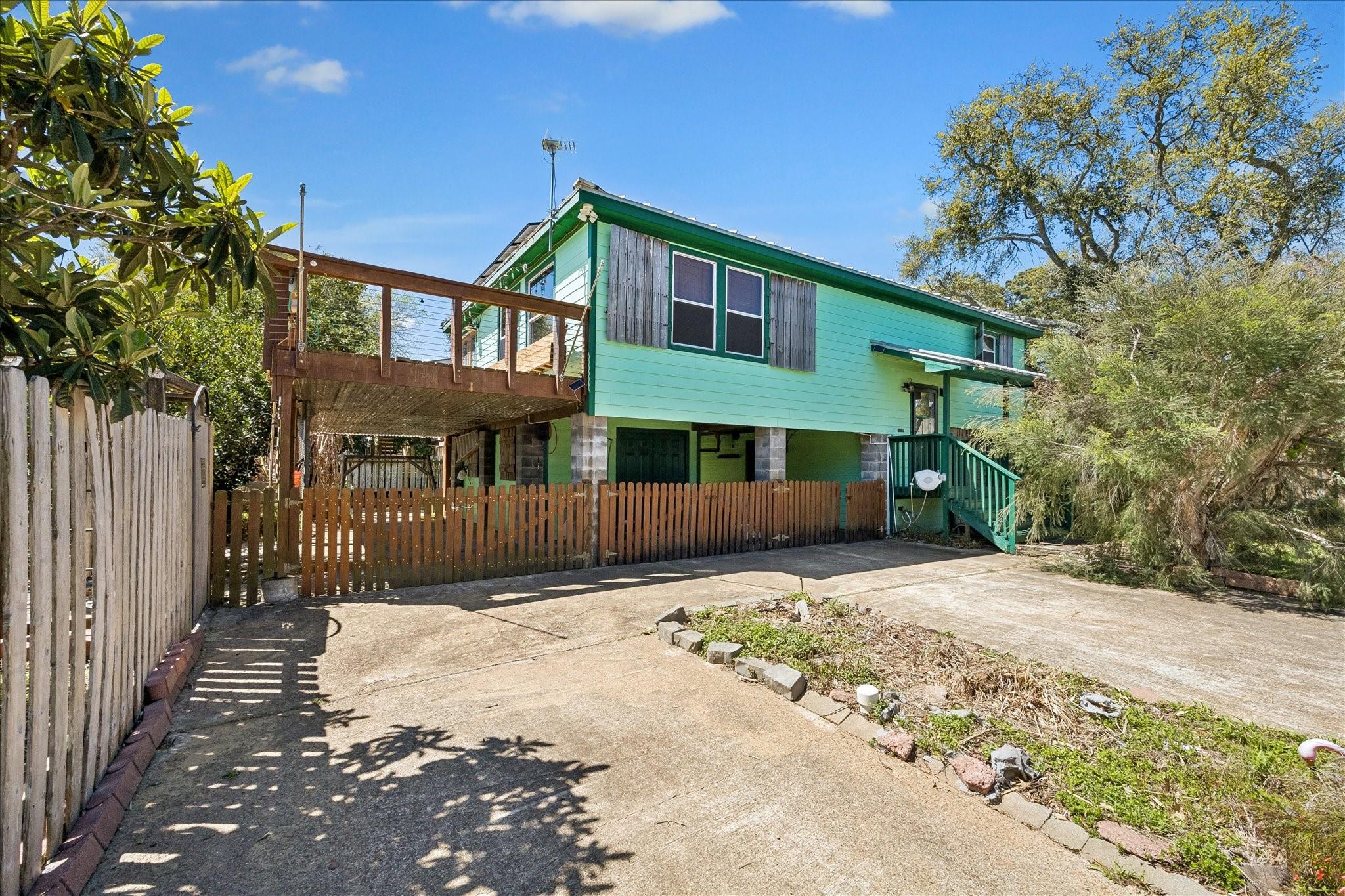 Image 2: Elevated home with a spacious driveway and covered