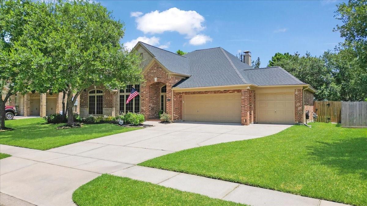Image 3: All brick. Mature trees and wide driveway.