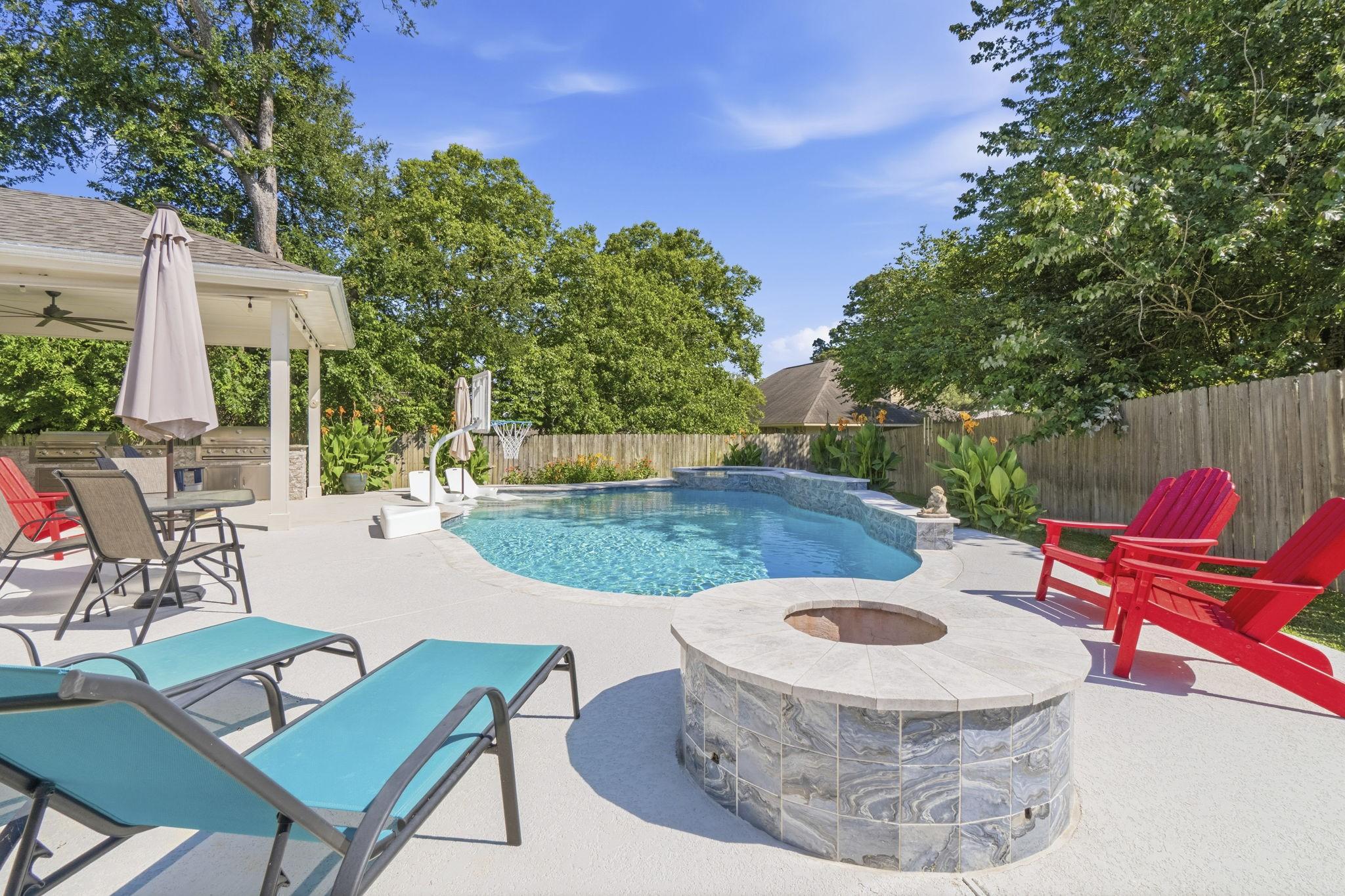 Image 1: Resort-style backyard showcases a sparkling pool,