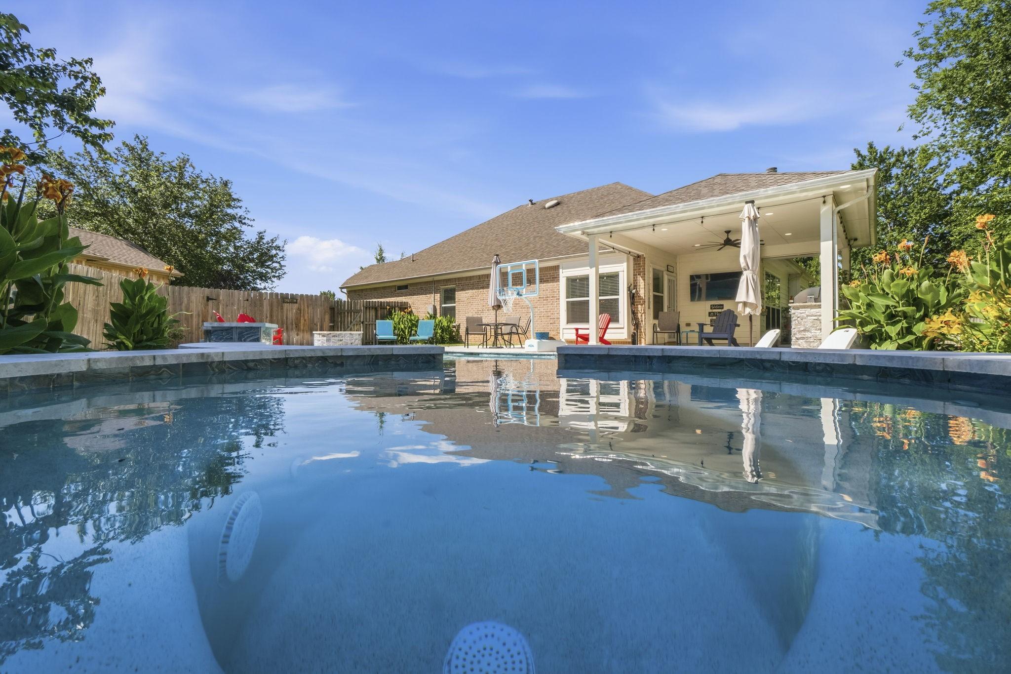 Image 4: Resort-style backyard retreat featuring a sparklin