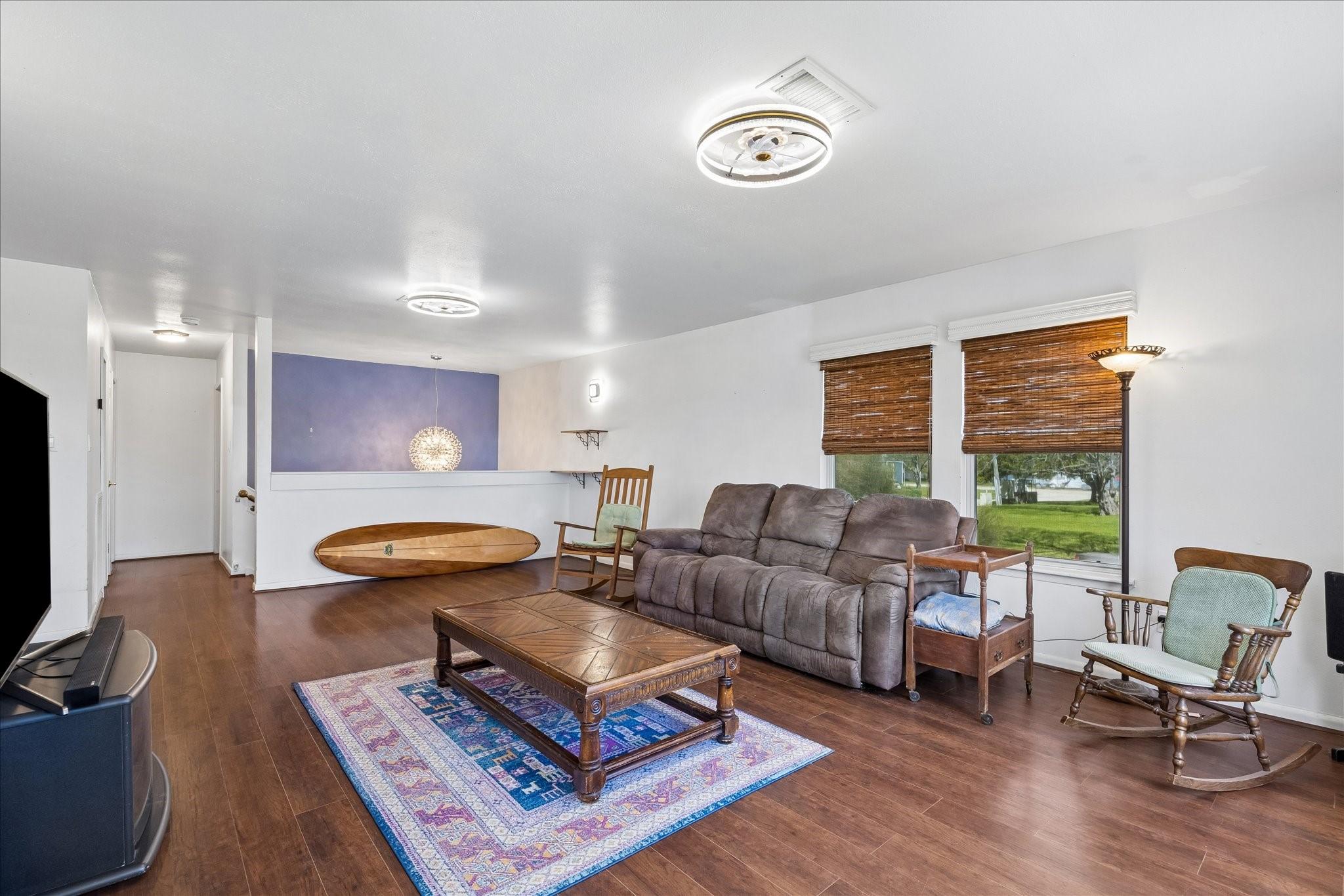 Image 3: Open living area with wood-style flooring and a se