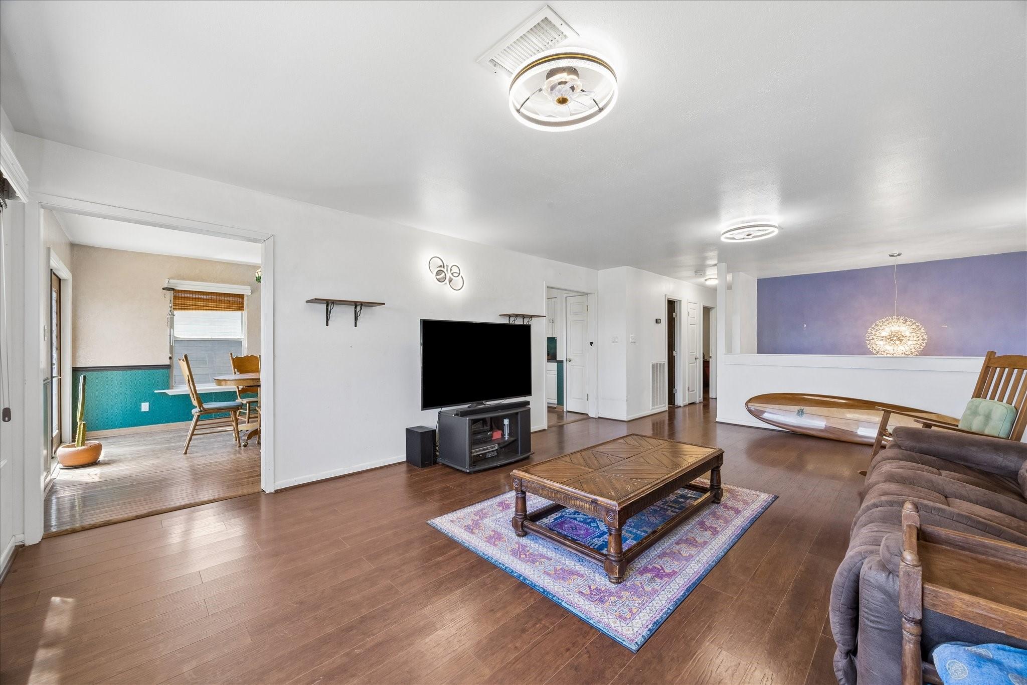Image 4: Open-concept living area with wood-style flooring