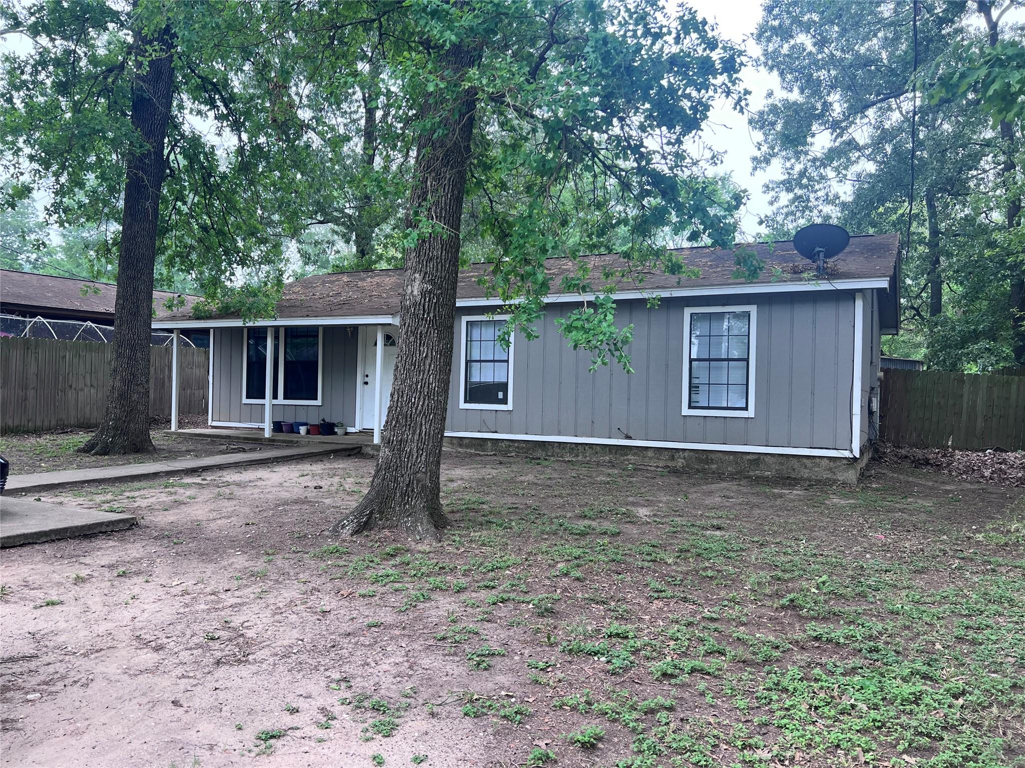 Image 2: Front yard shaded by trees.