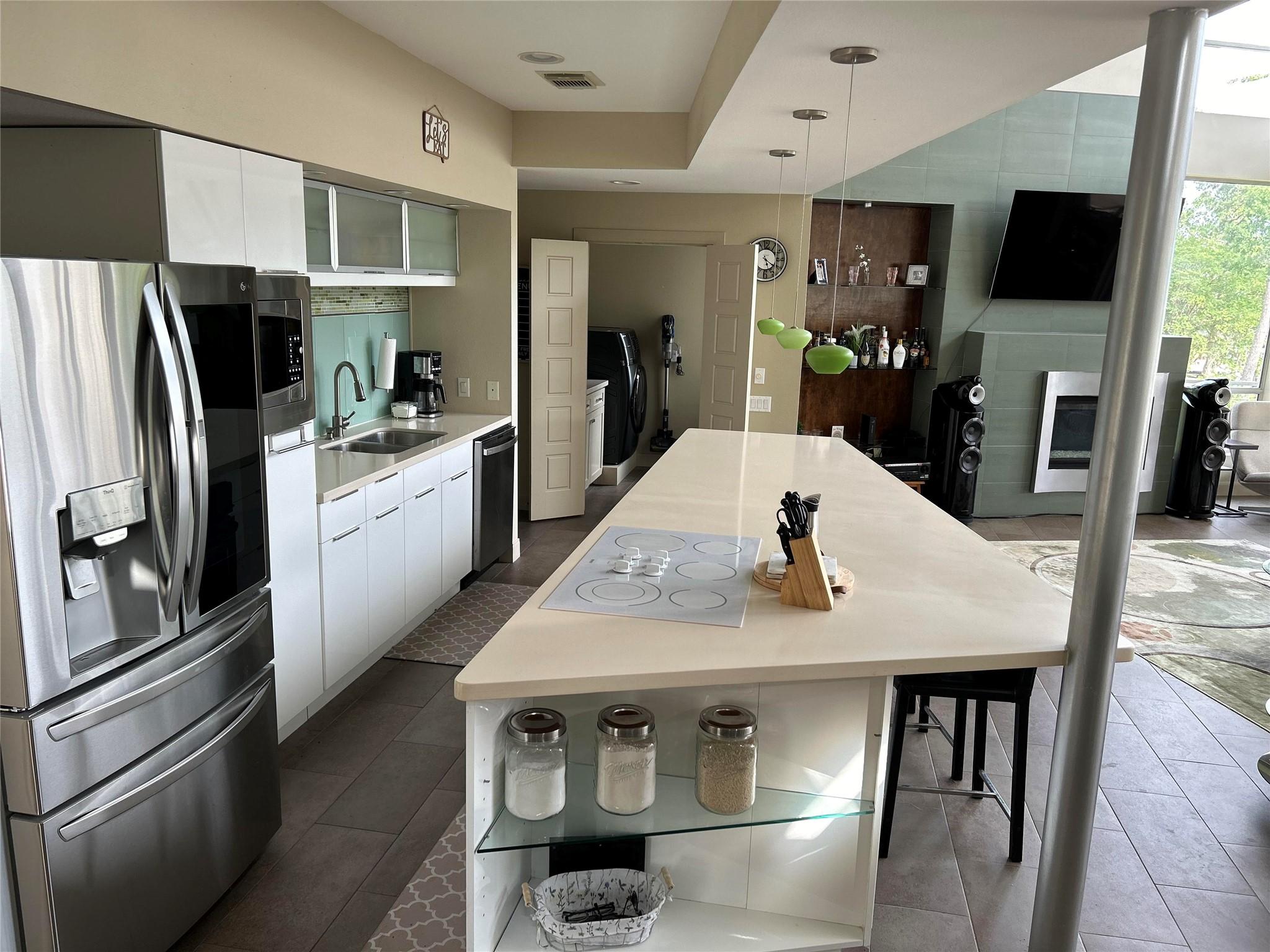 Image 4: VIEW FROM KITCHEN TO LIVING ROOM AND LAKE