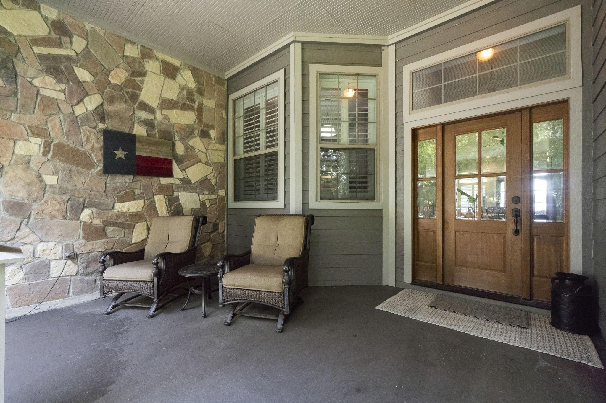 Image 3: This welcoming porch features a cozy seating area