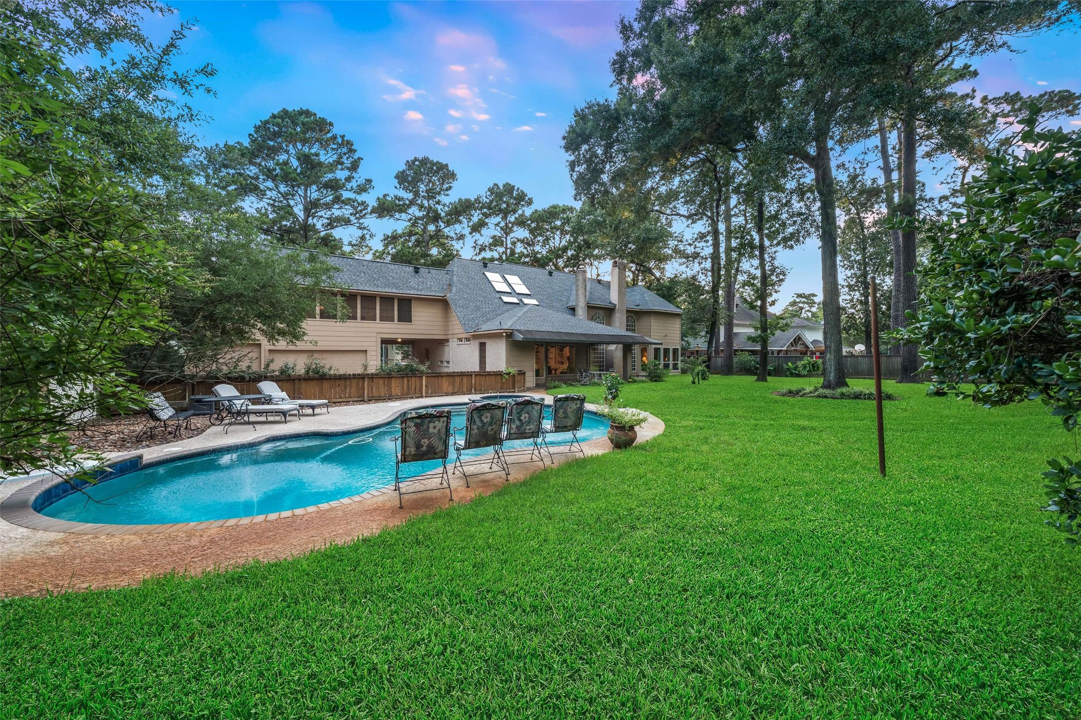 Image 2: Spacious backyard with a large, inviting pool surr