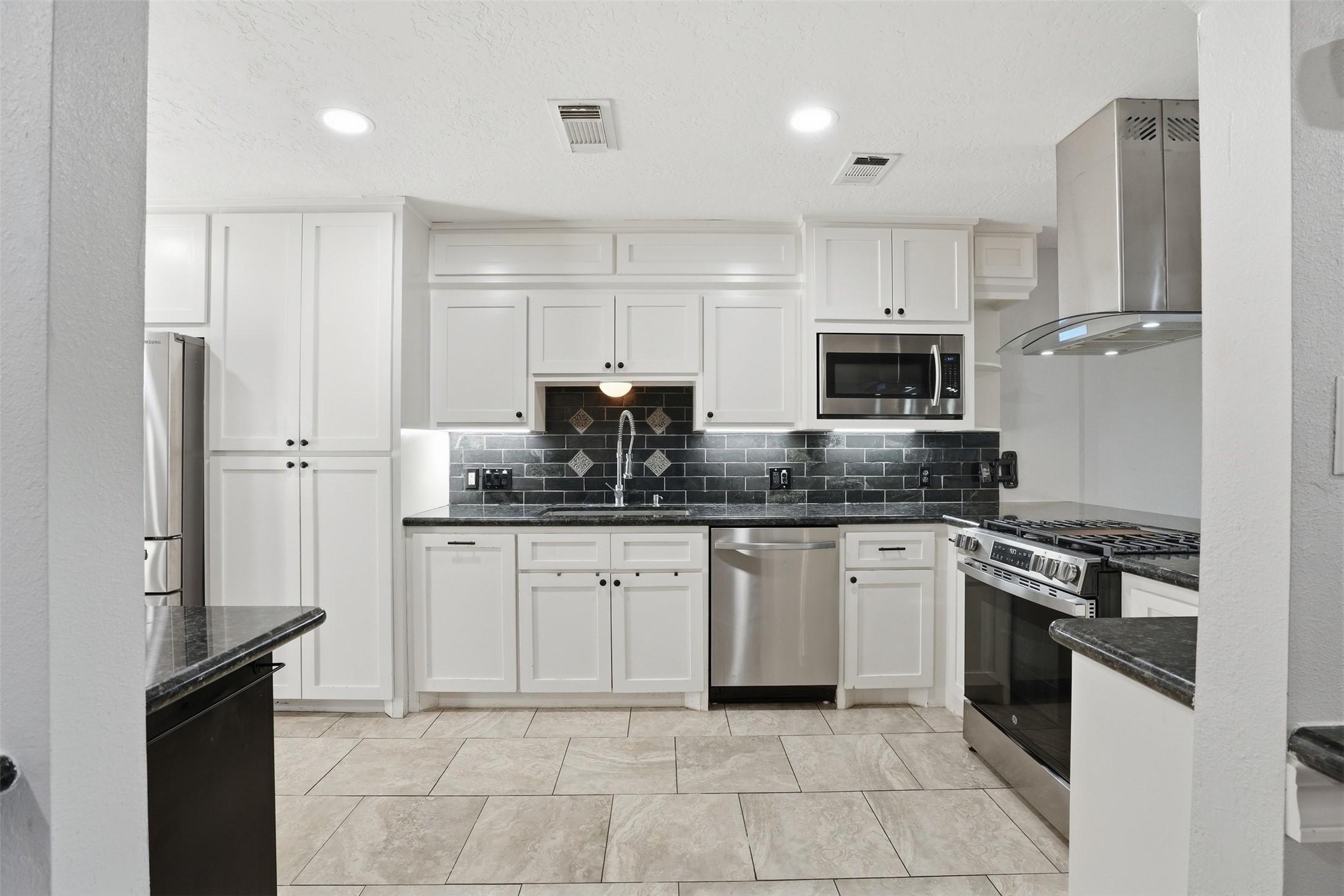 Image 1: Modern kitchen with white cabinetry, stainless ste