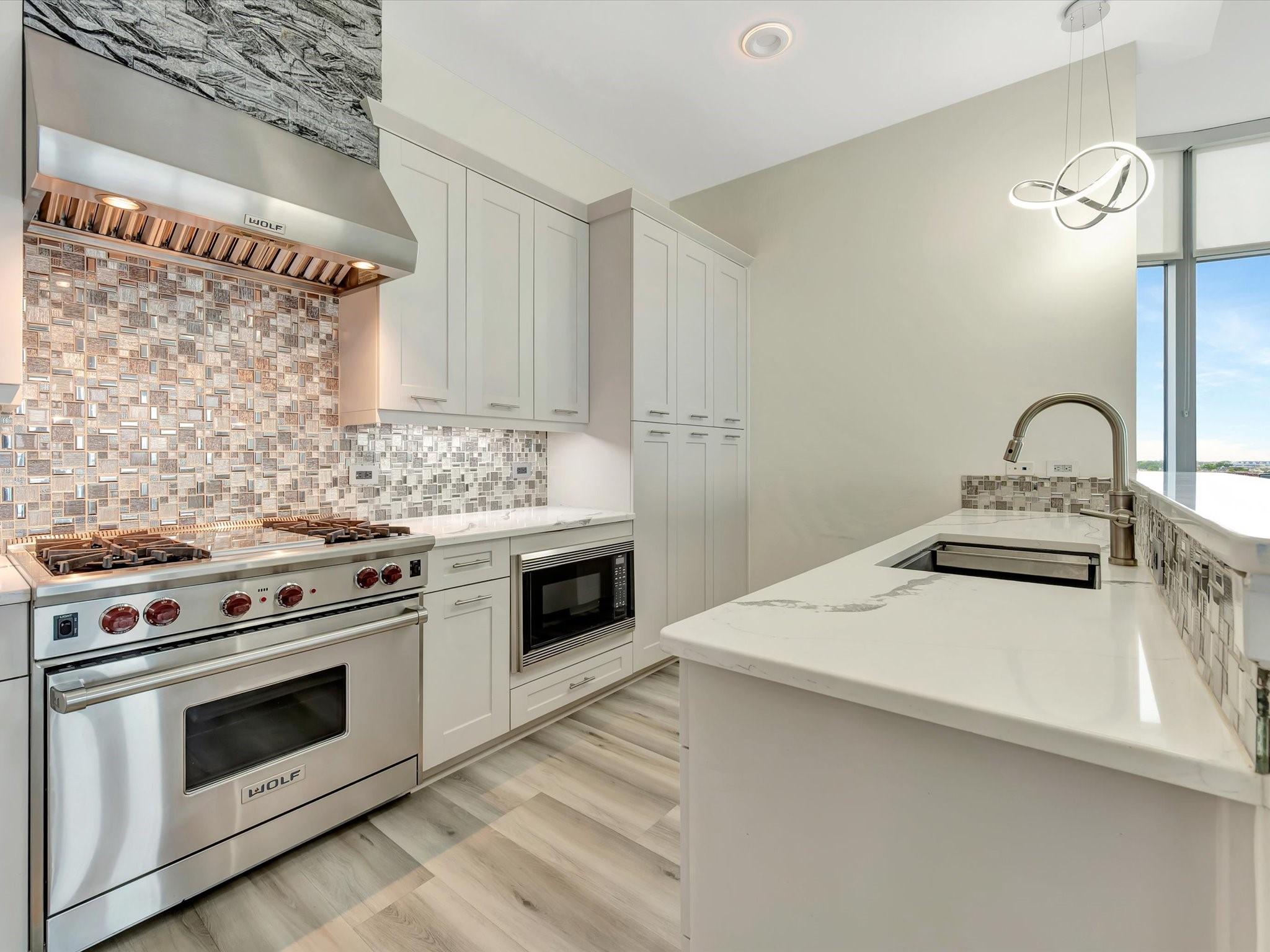 Image 3: The kitchen offers a Wolf stove, gas oven, microwa