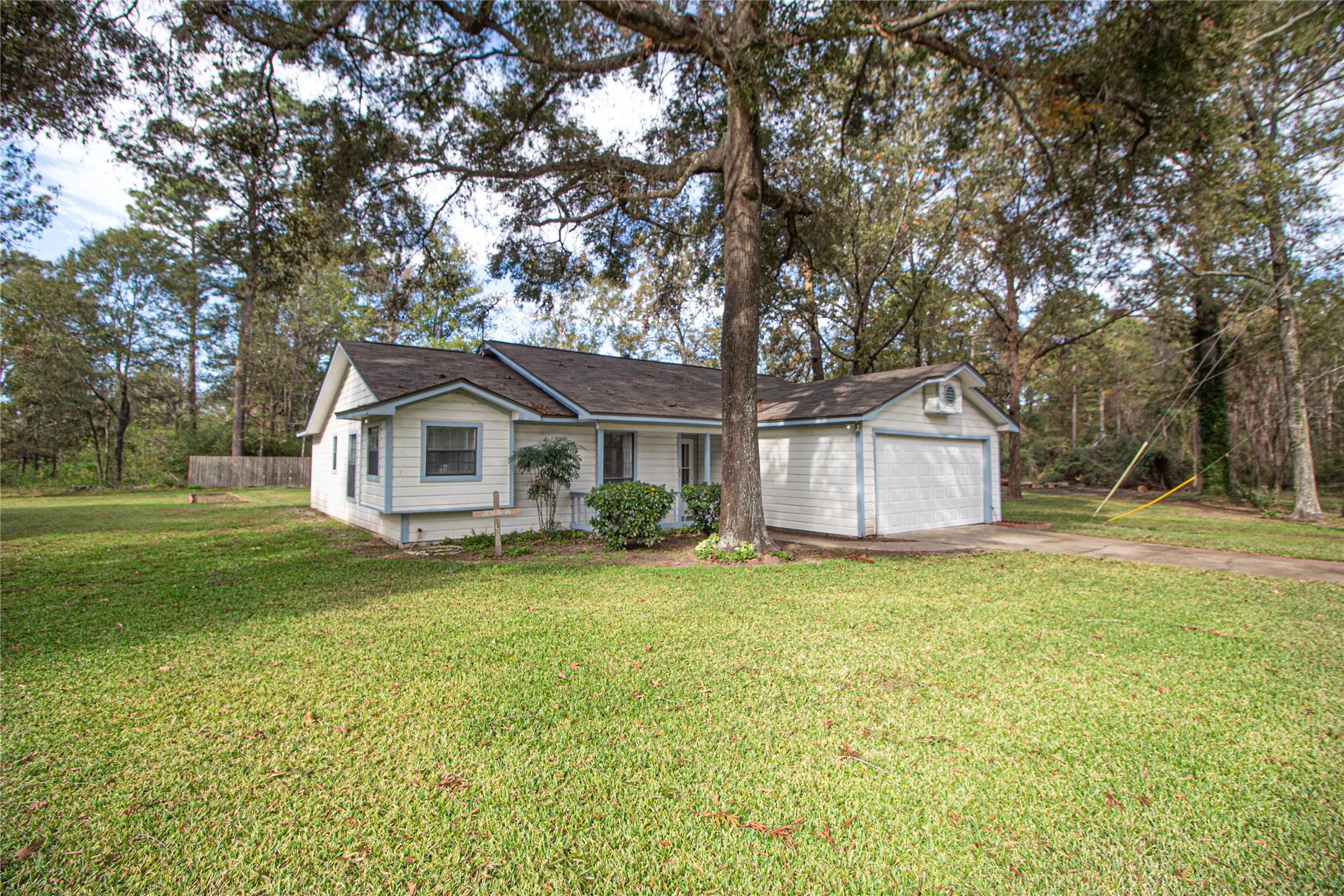 Image 2: Property has a well-maintained lawn and mature tre