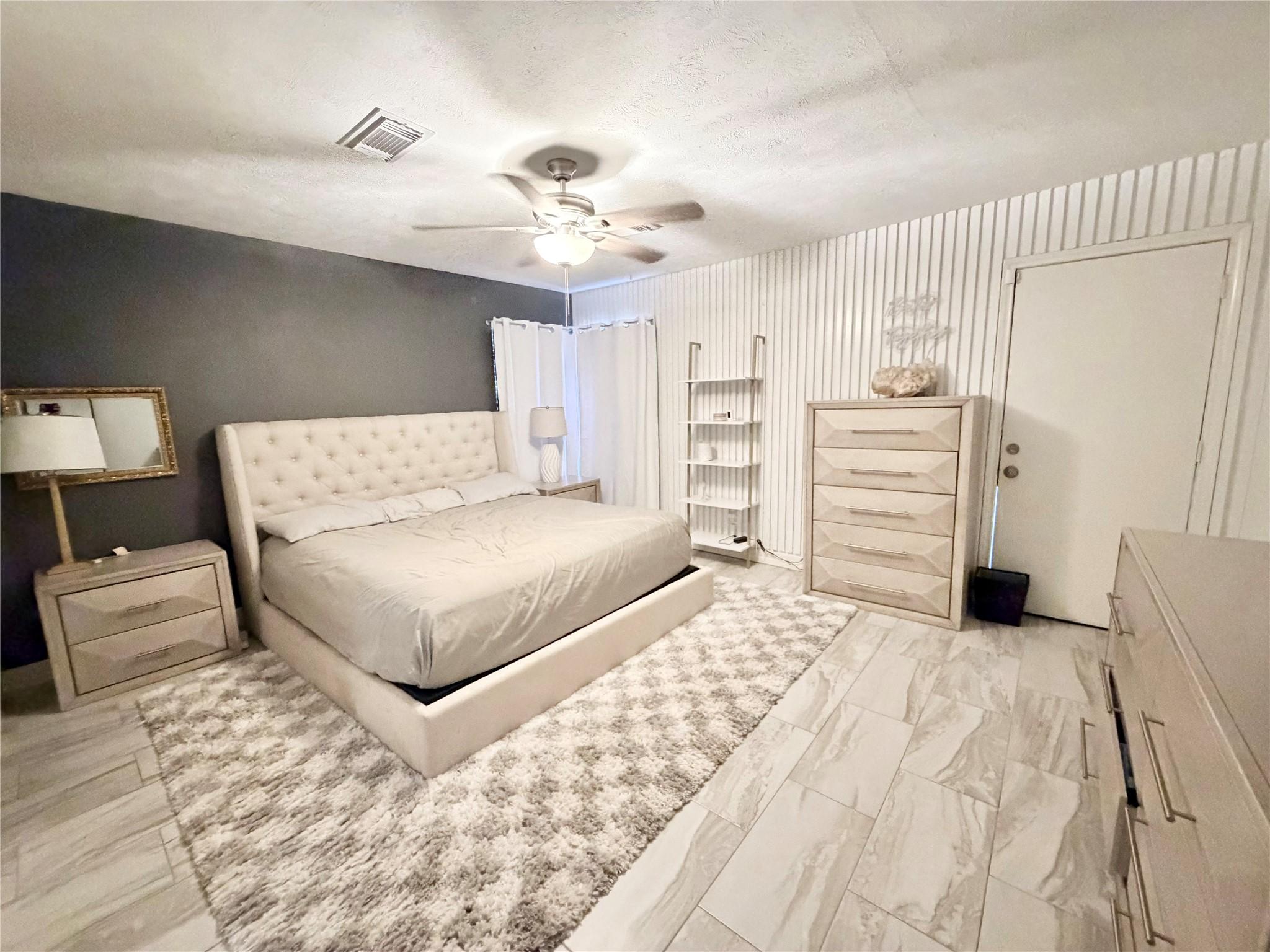 Image 2: Spacious bedroom with a modern design, featuring a