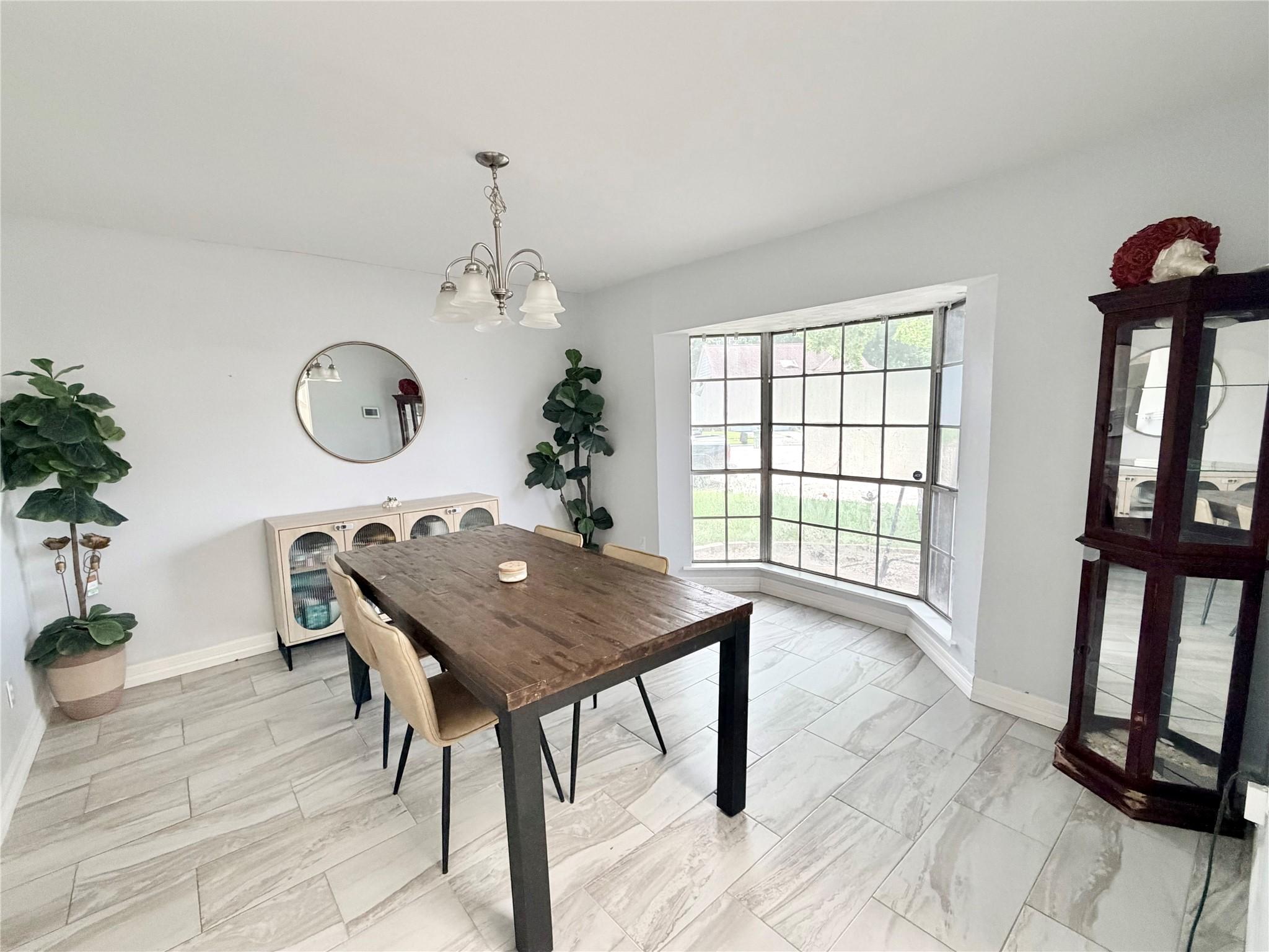 Image 4: Bright dining area with large bay window, elegant