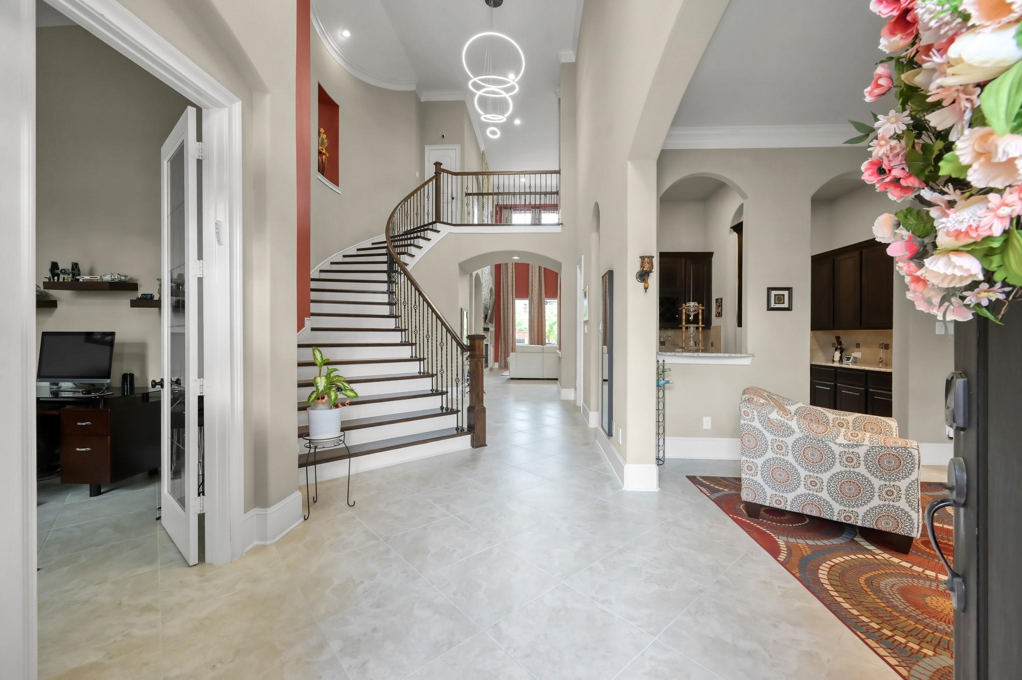 Image 4: This elegant entryway features a grand curved stai