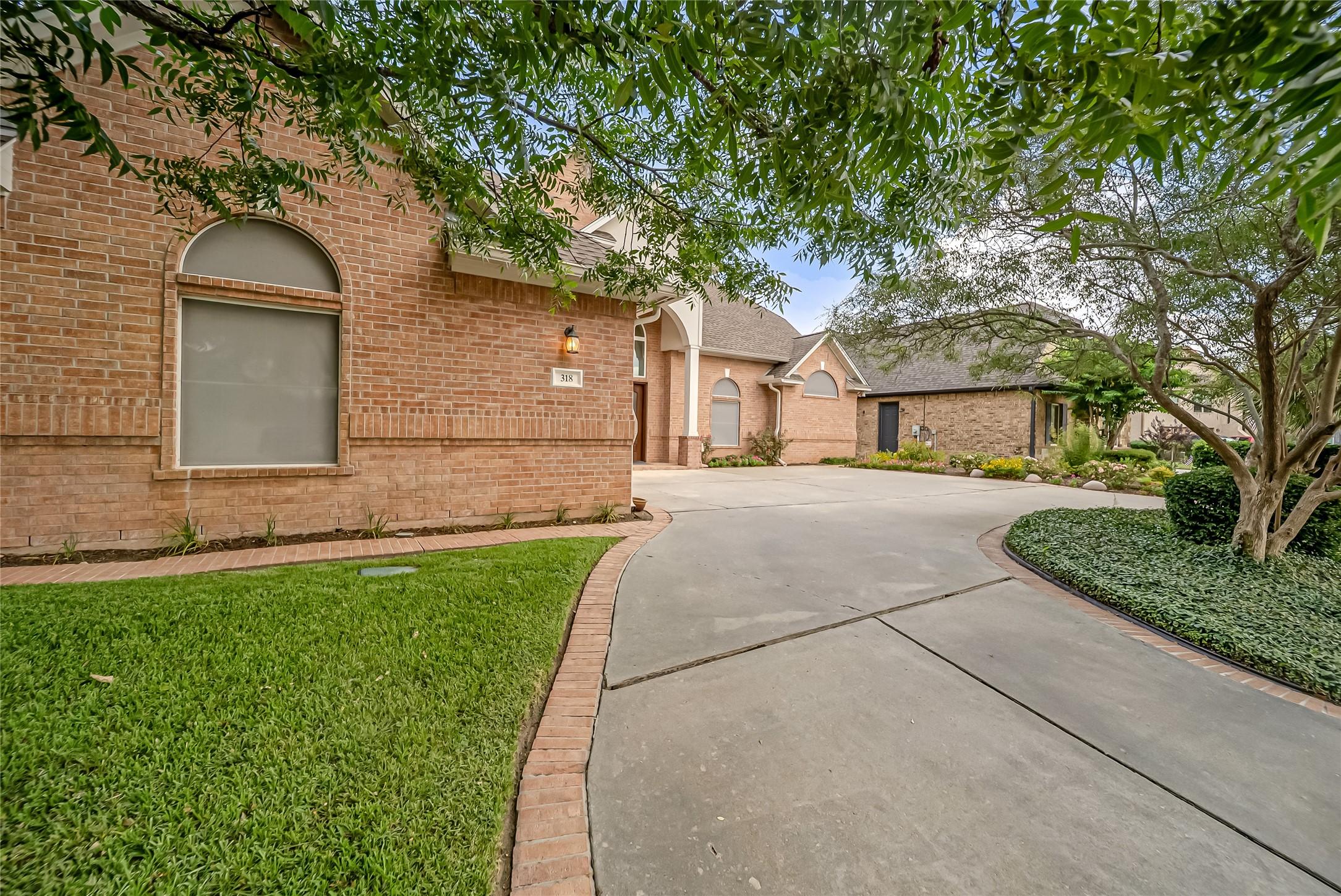 Image 4: Lush landscaping, mature trees, and an expansive c