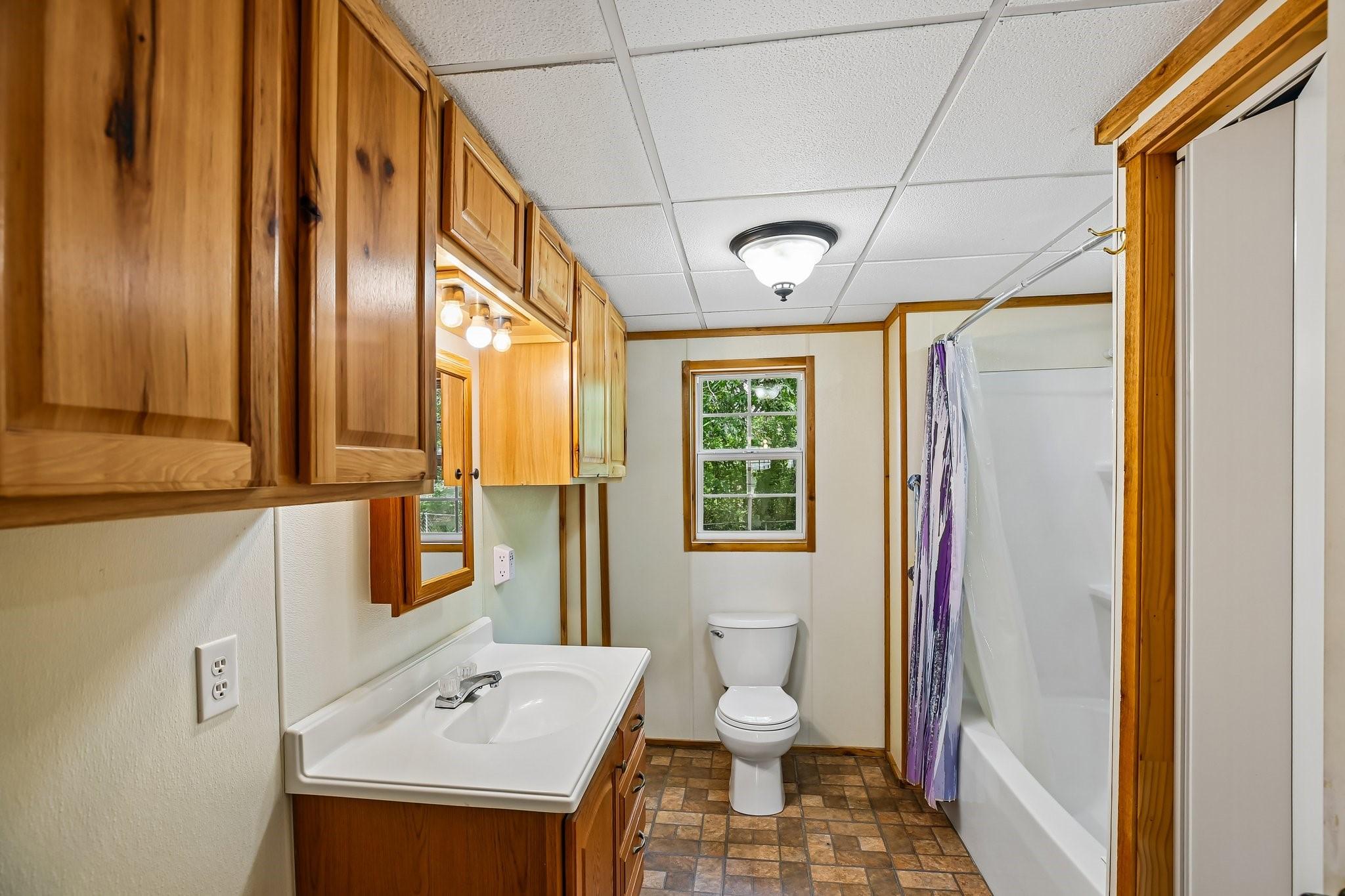 Image 4: A bright and functional full bathroom features a s