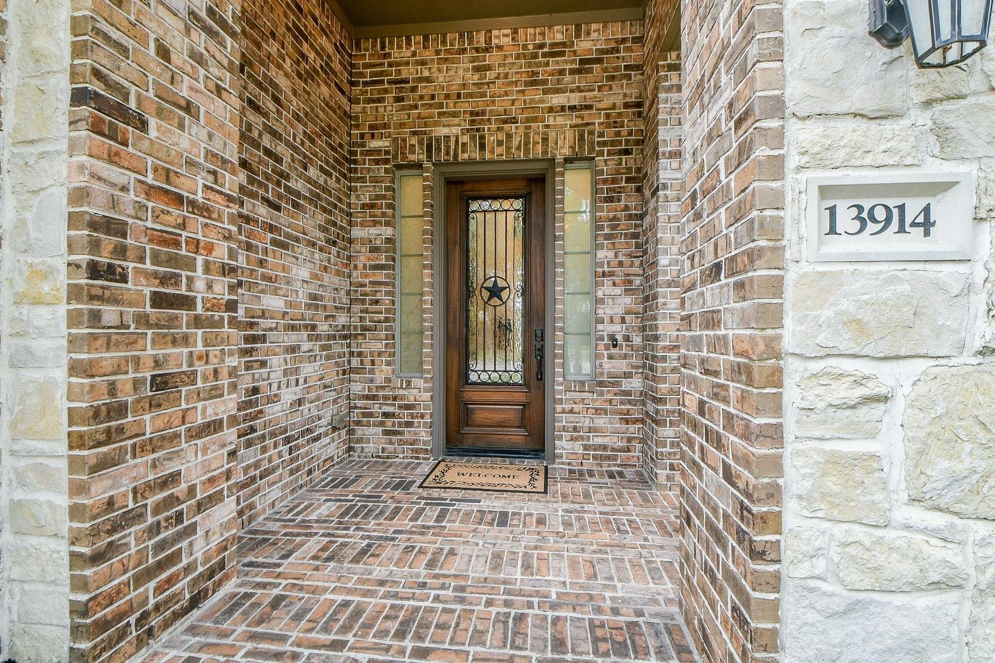 Image 4: Grand brick-covered entry featuring a freshly stai
