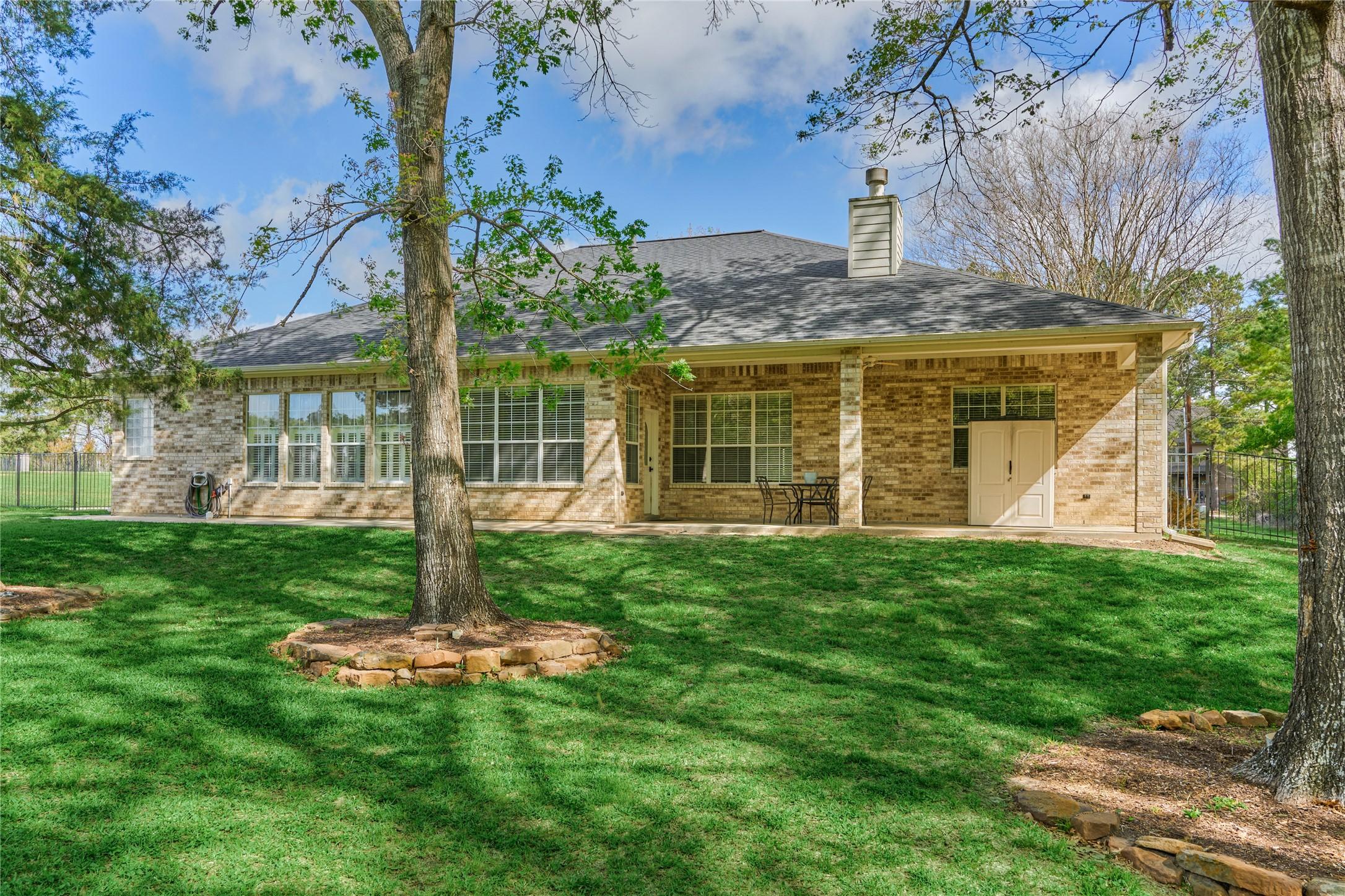 Image 3: Spacious backyard, featuring a covered patio and l