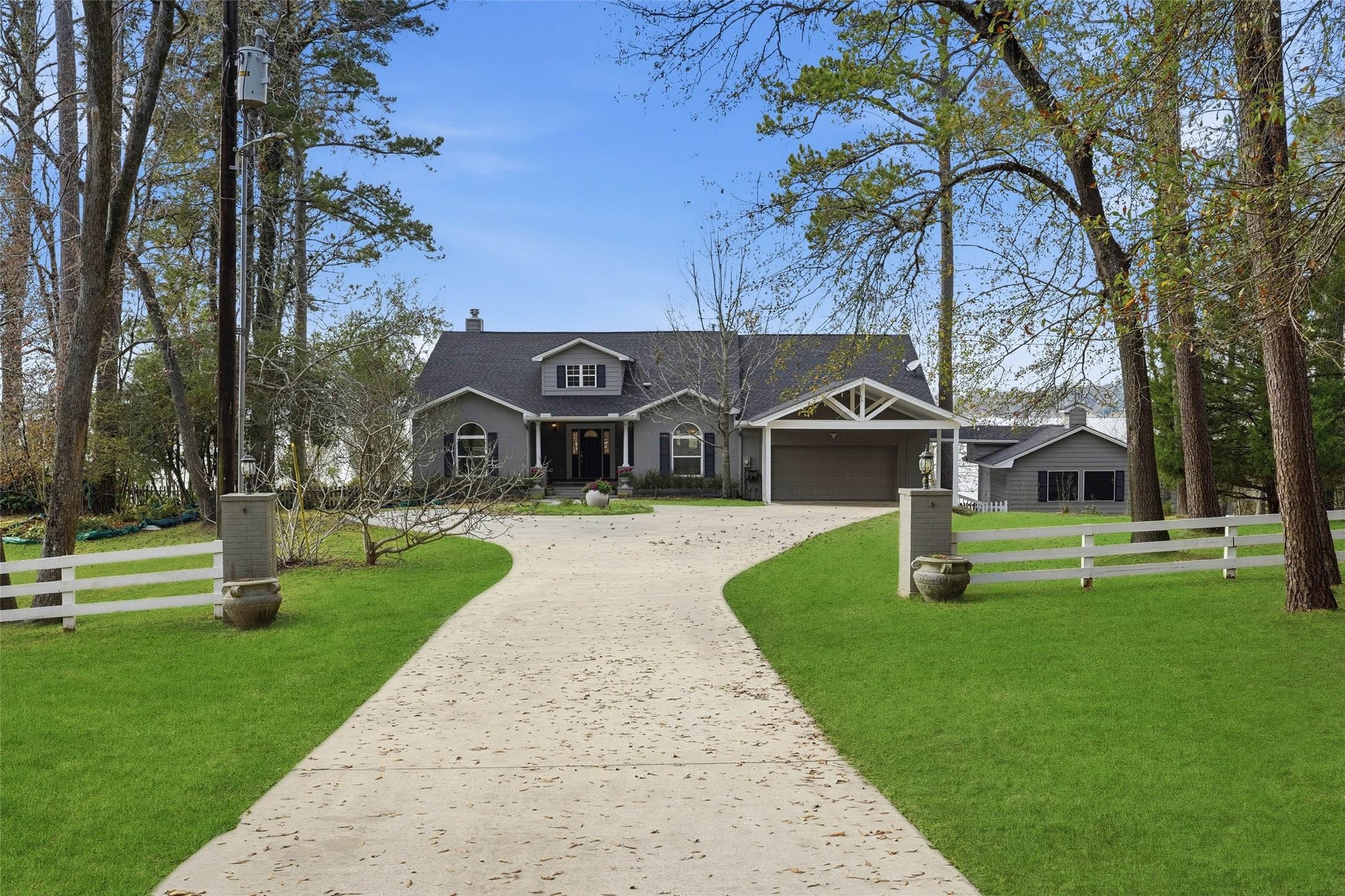 Image 2: You're greeted by a tree-lined driveway with circl