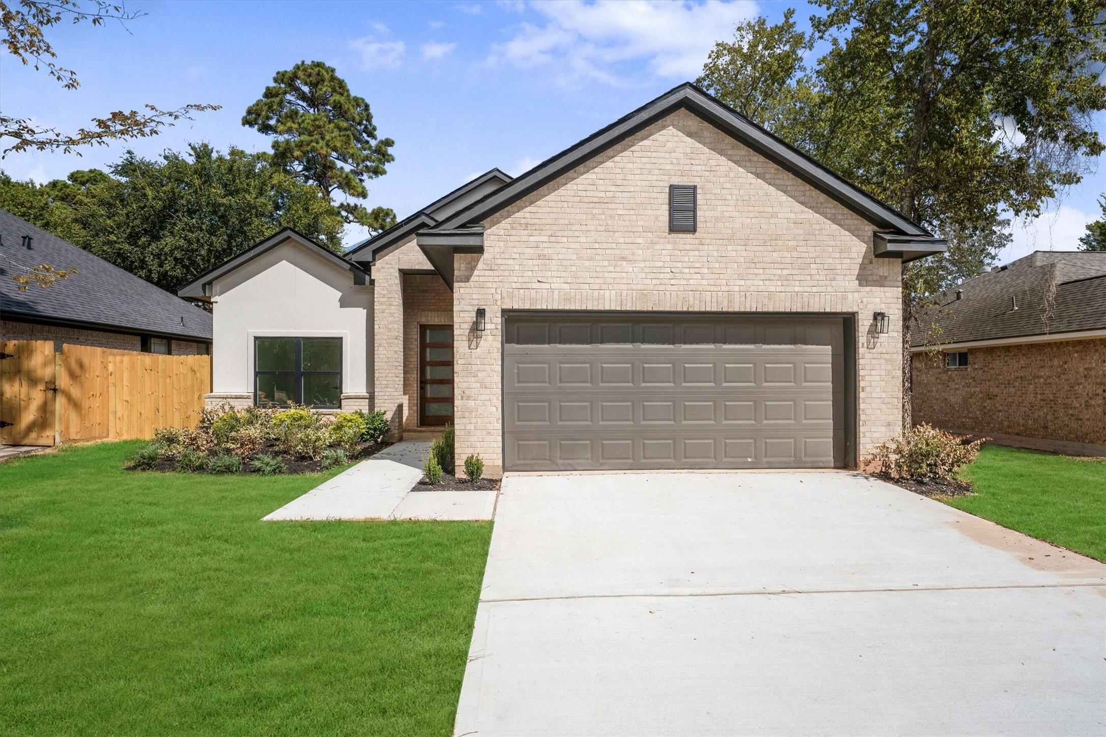 Image 2: This modern home features a clean brick facade wit